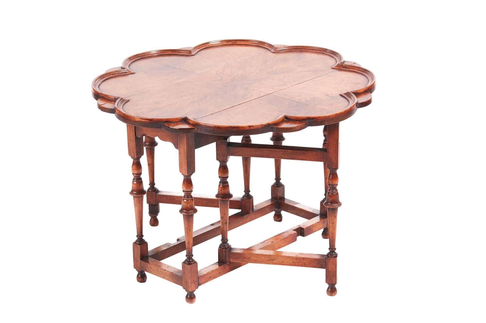 Outstanding walnut drop-leaf coffee table, having a fantastic walnut shaped top with a moulded edge and two drop leaves, supported by eight solid walnut William and Mary style legs with ball feet united by solid walnut stretchers.