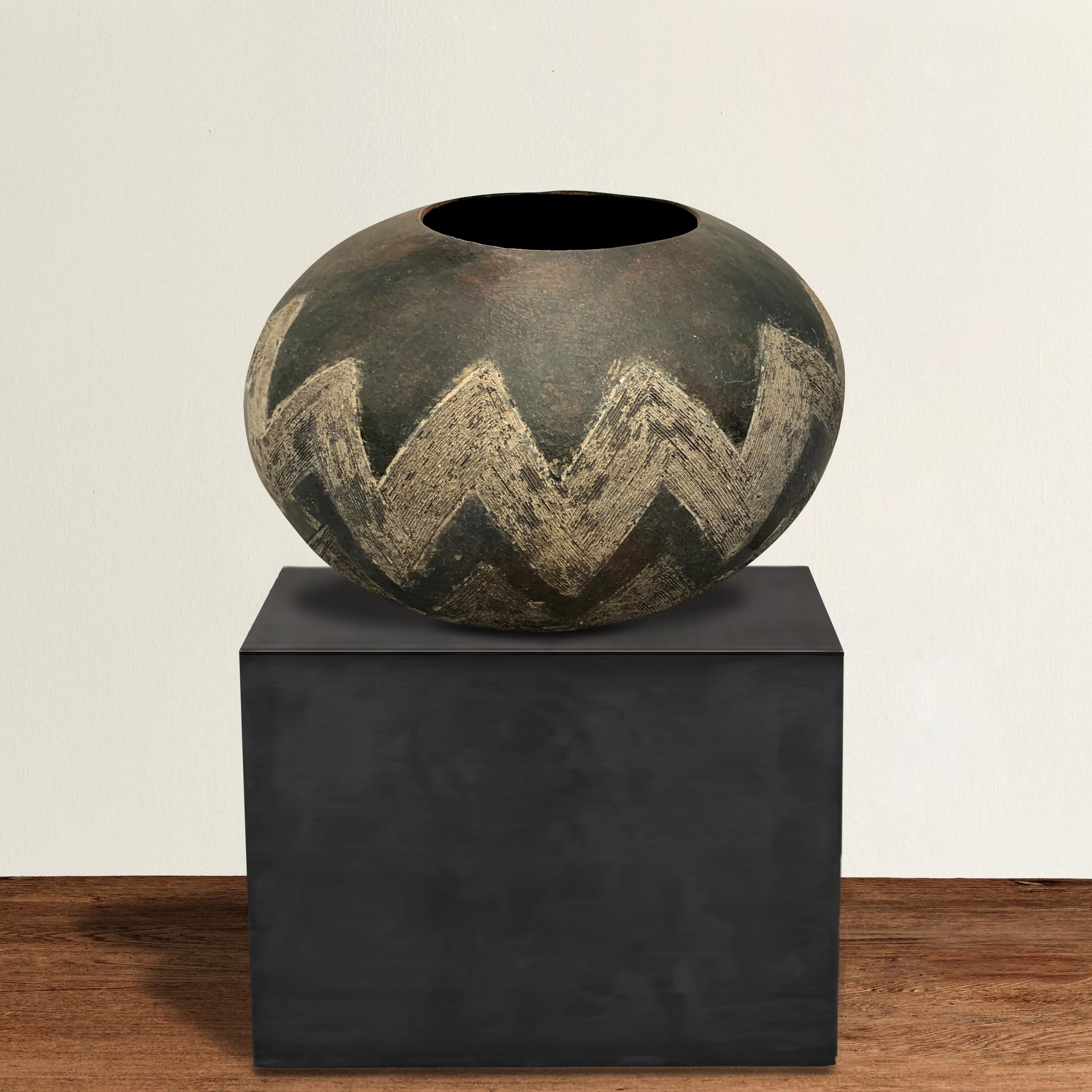 An outstanding 20th century monumental tribally-used Zulu hand-built ceramic beer pot with two wide incised chevron bands running around the perimeter of the pot.