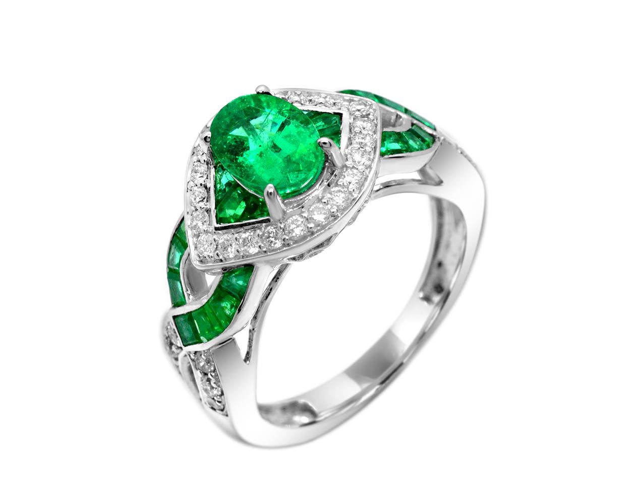 This cross-over emerald and diamond cocktail ring is 14 Karat white gold. It has a protective feel with its subtle green colored evil-eye shape.

Size 7 x 5 oval 0.85 carat emerald center
0.60 carat baguette emeralds
0.30 cttw white diamonds
14k