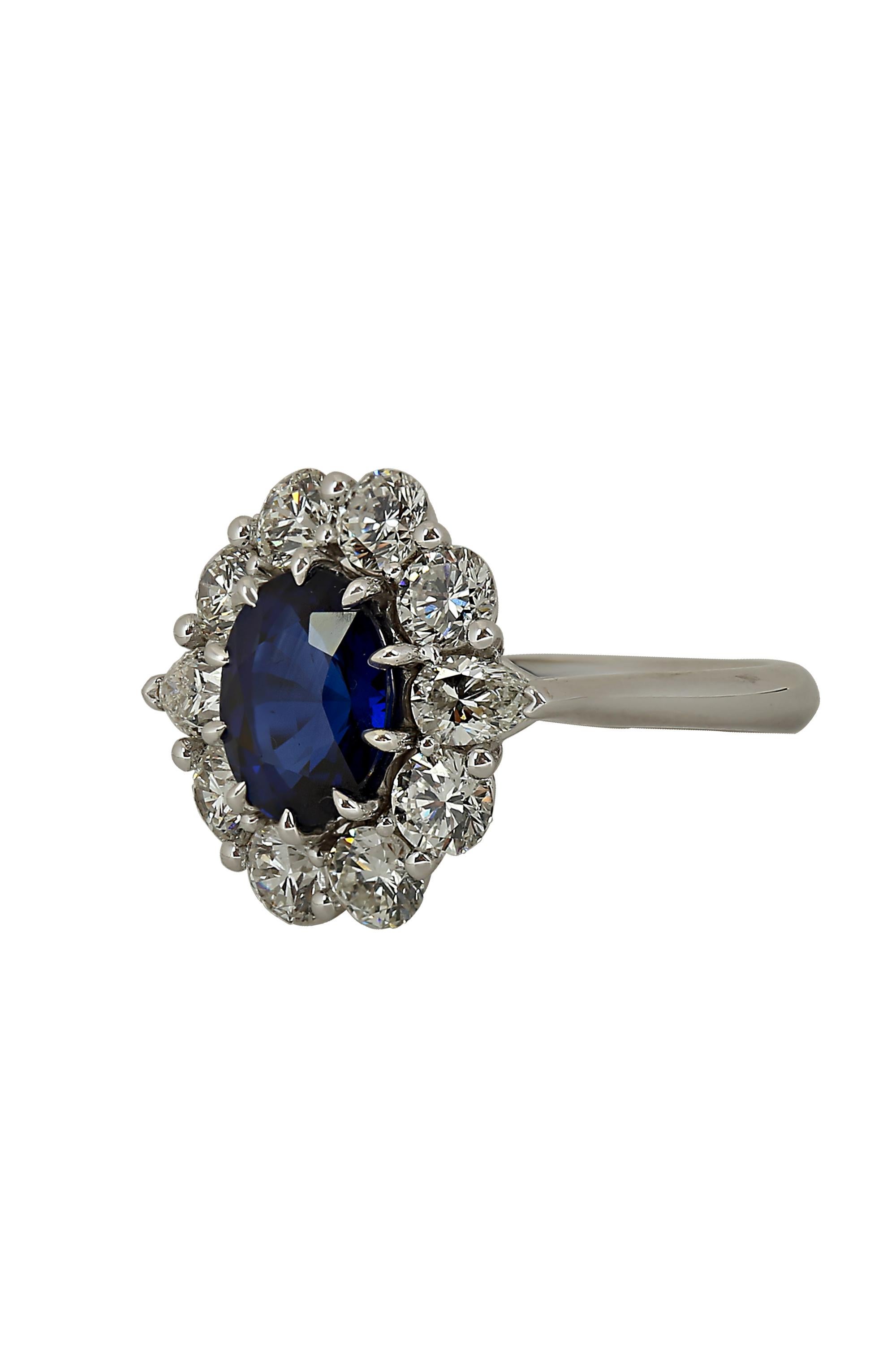 Designed and created by Gems Are Forever, Inc. Beverly Hills, this elegant and striking ring features a rich royal blue oval sapphire weighing 2.73 carats, beautifully set off by bright round brilliant diamonds enhanced by two pear shaped diamonds.