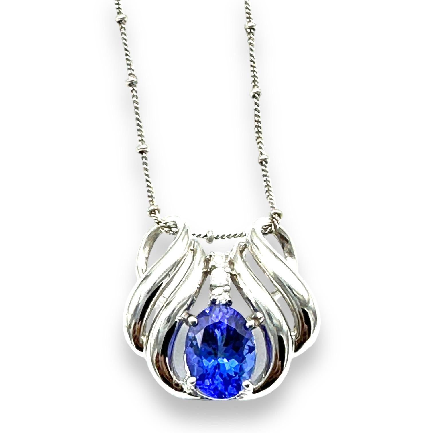 14K white gold diamond and tanzanite slide pendant on chain measuring 25mm x 23mm wide. The chain is 18 inches in length.
The tanzanite is a beautiful oval-shaped gemstone measuring 11 x 8.50 mm in diameter and is estimated as 3.00 carats. Accenting