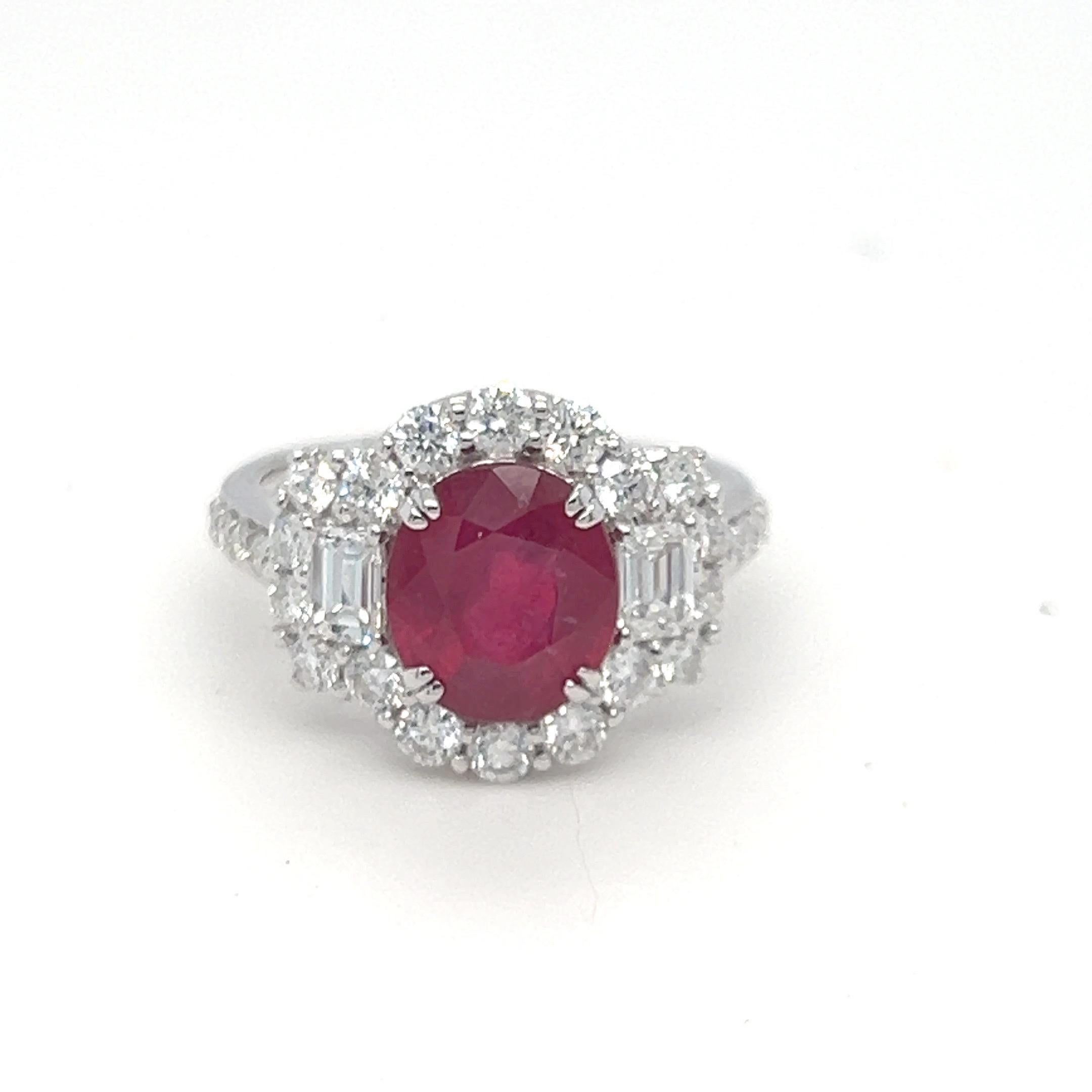 This stunning ring features a 3.65-carat oval ruby, beautifully framed by two emerald-cut diamonds set east-west, with additional brilliant-cut diamonds enhancing its design. The total diamond weight is 1.53 carats, graded F color and VS clarity,