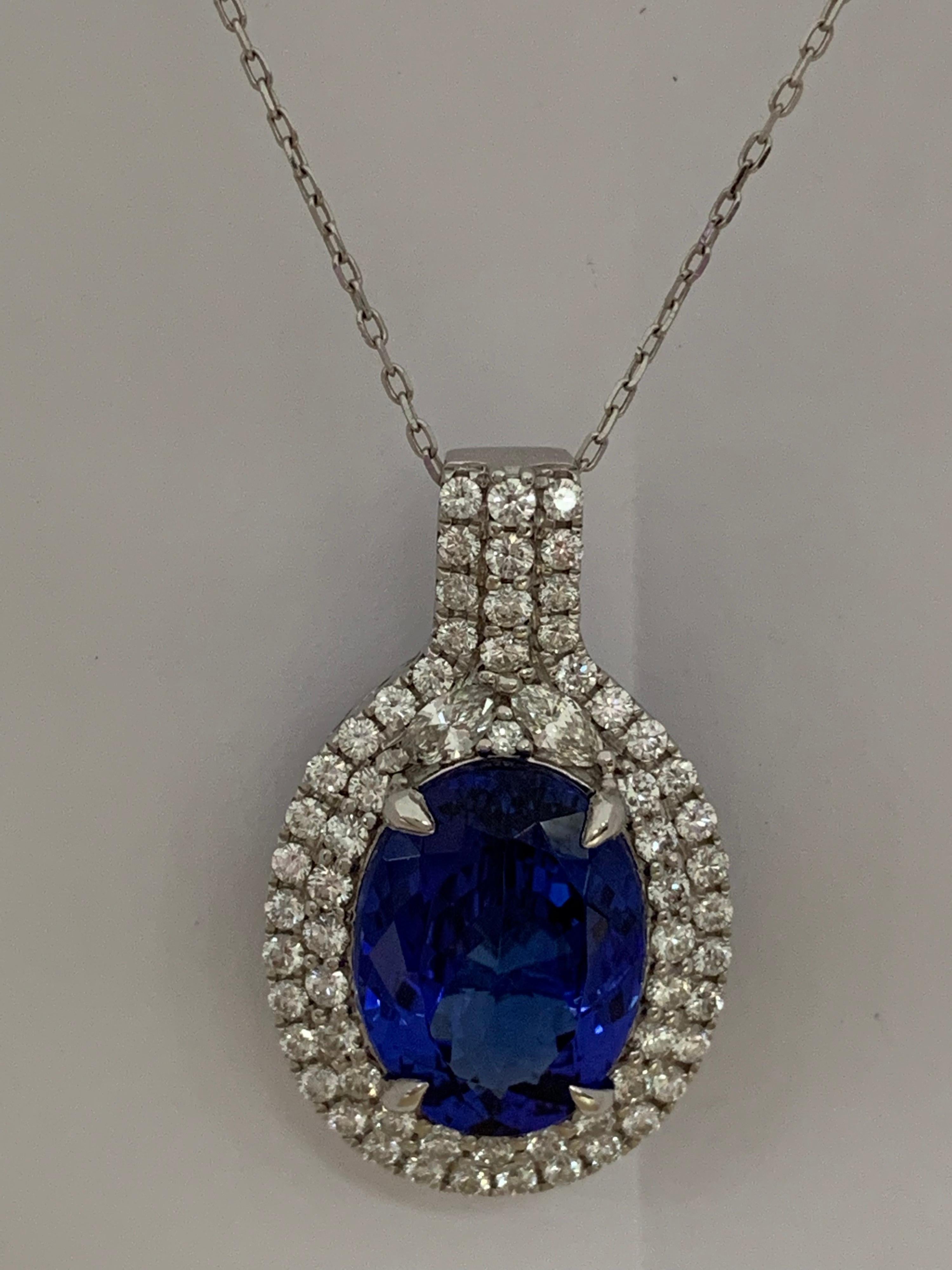 Natural AAA quality 9.51 Carat Oval Tanzanite and 1.56 Carat white diamond set in 14 Karat gold is one of a kind handcrafted Pendant. The pendant include 18 Karat white gold.