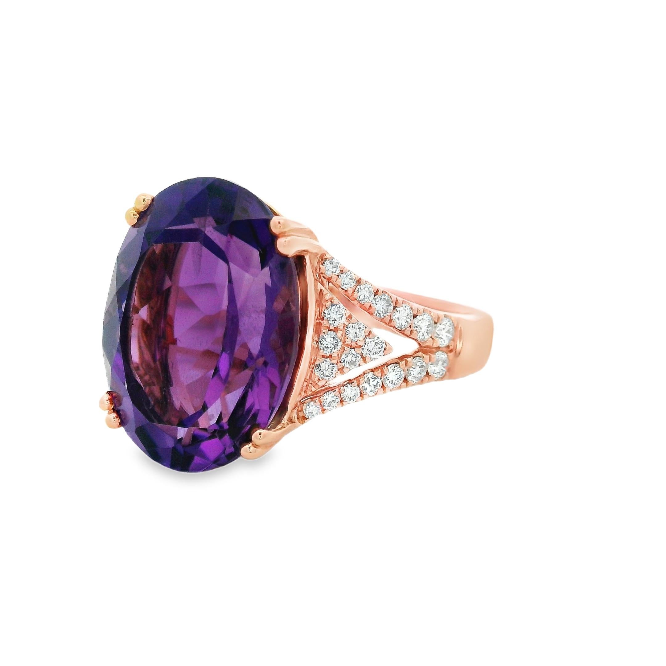 This striking cocktail ring centers on a vivid 9.05-carat oval amethyst, measuring 16 x 12mm, set in warm 14K rose gold. The richly saturated purple stone is prong-set to allow maximum light play, while its elongated oval shape lends elegance and