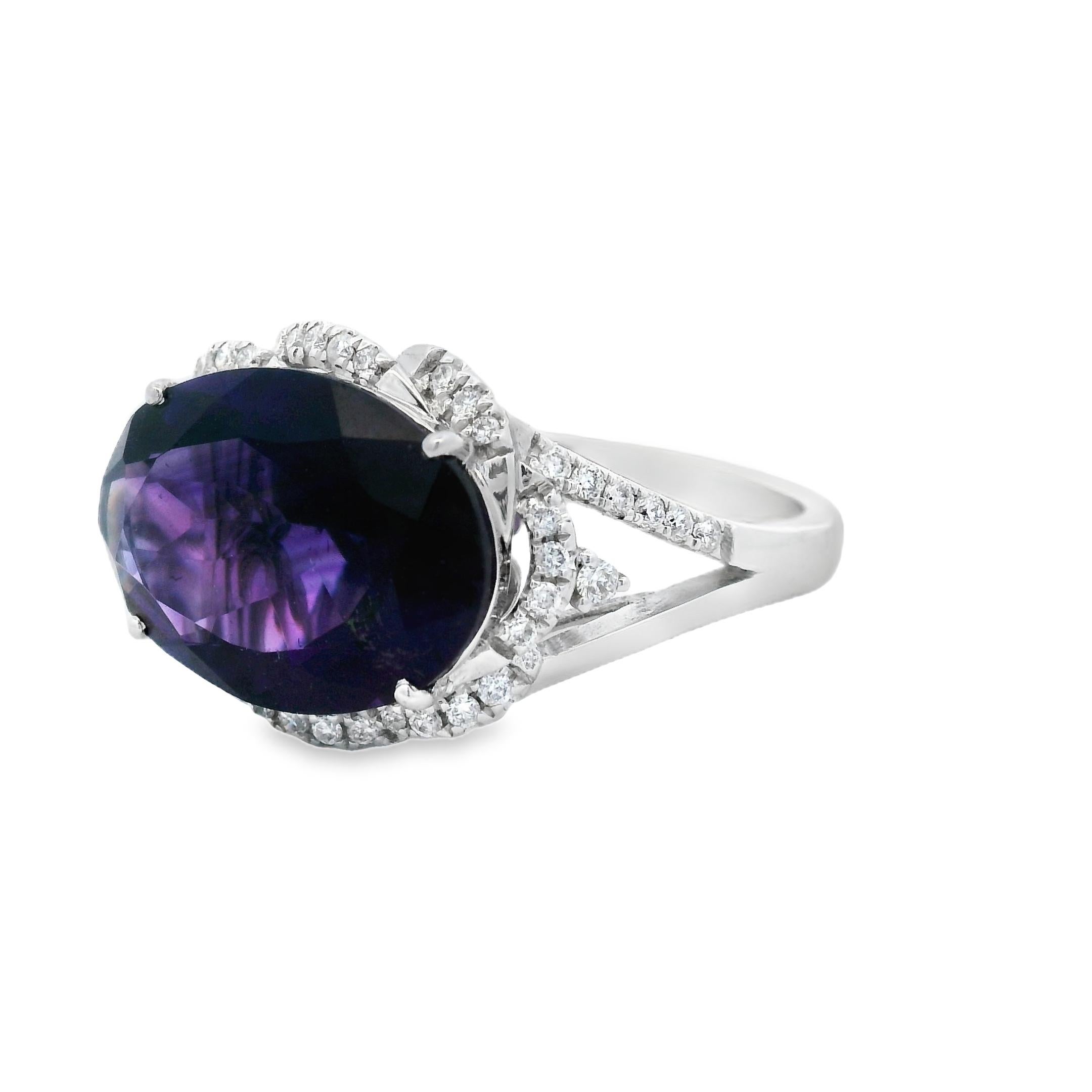 Questo audace ed elegante anello da cocktail presenta un'ametista ovale da 4,90 carati, con dimensioni di 14x10 mm, incastonata in un'aureola di diamanti che aggiunge brillantezza da ogni angolazione. Il centro viola vivido è circondato da 44