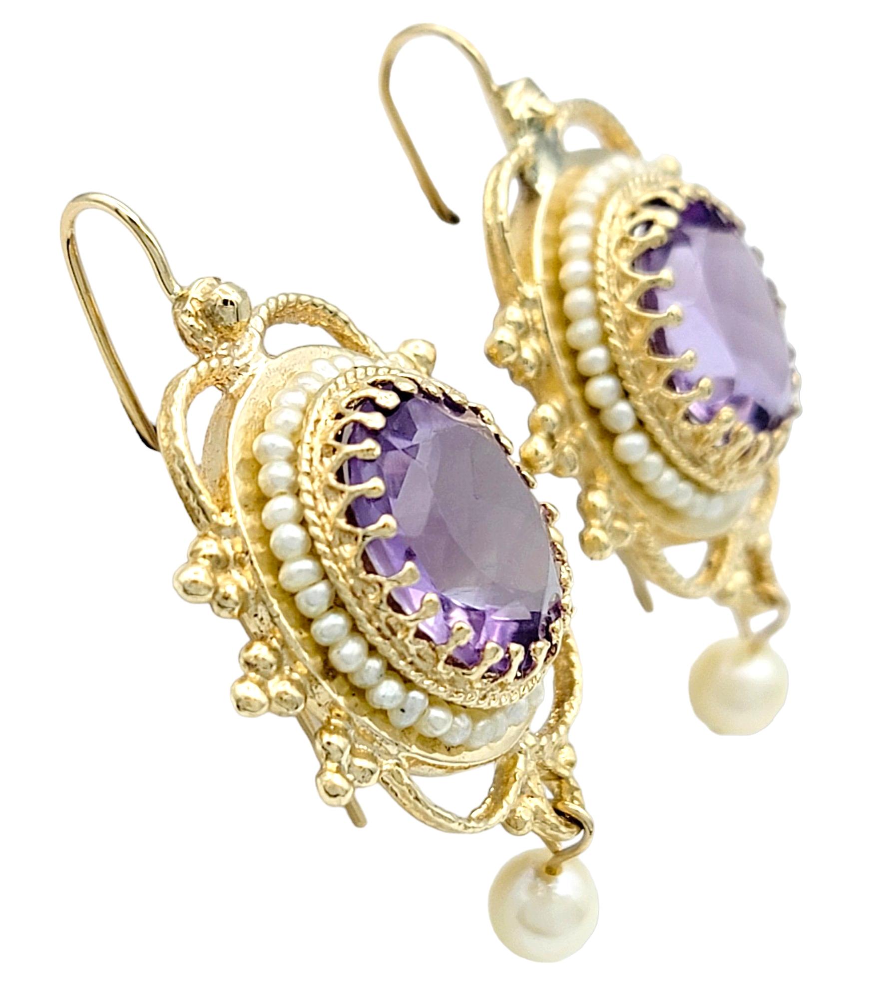 These exquisite earrings showcase an elegant blend of timeless sophistication and artistic craftsmanship. Fashioned from lustrous 14 karat yellow gold, each earring features a captivating oval amethyst nestled at its center, accented by a delicate