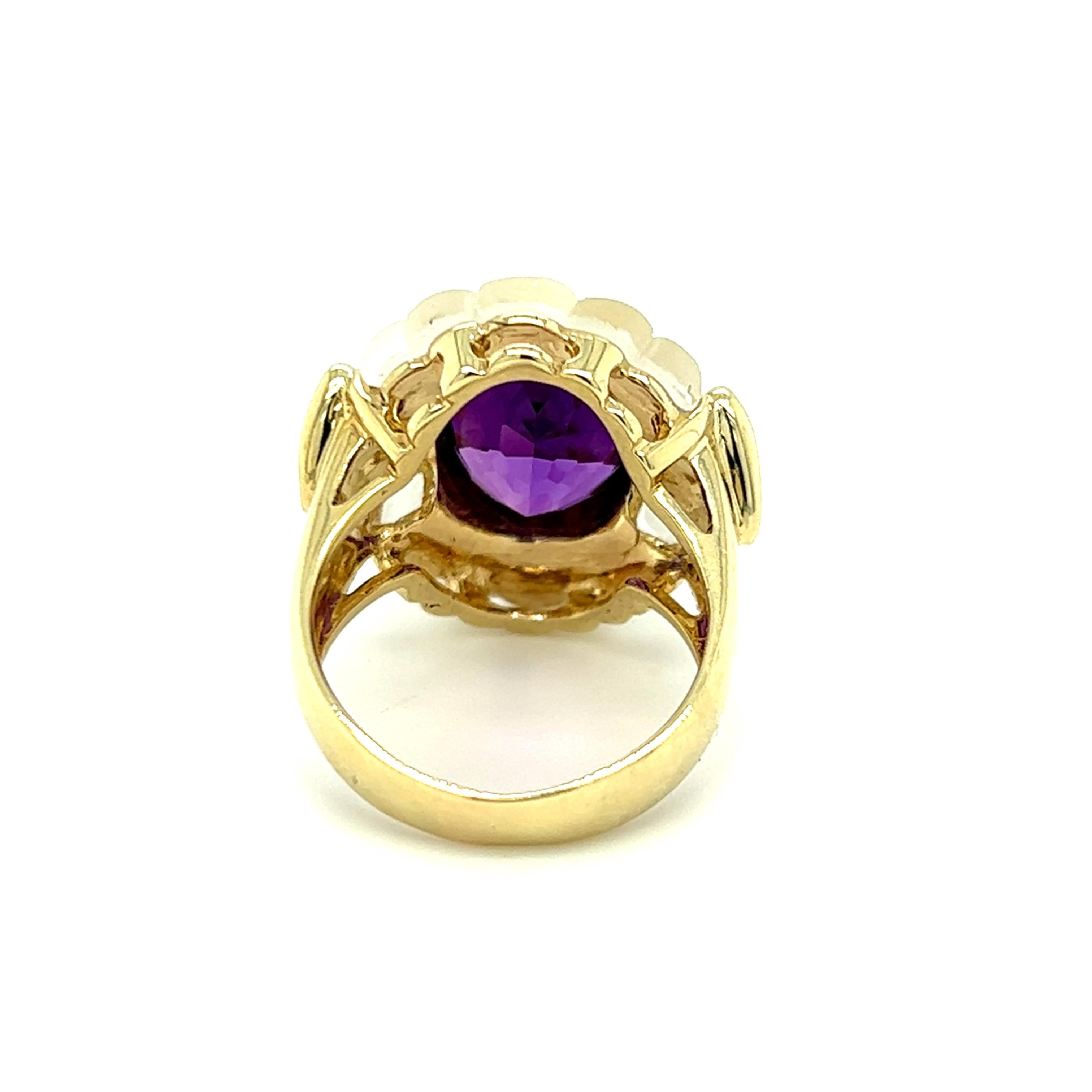 One 14 karat yellow gold ring bezel set with one 11x9mm oval amethyst, two carved white glass crystals, and eight (8) round brilliant cut diamonds, approximately 0.16 carat total weight with matching H/I color and SI1 clarity. The ring is stamped