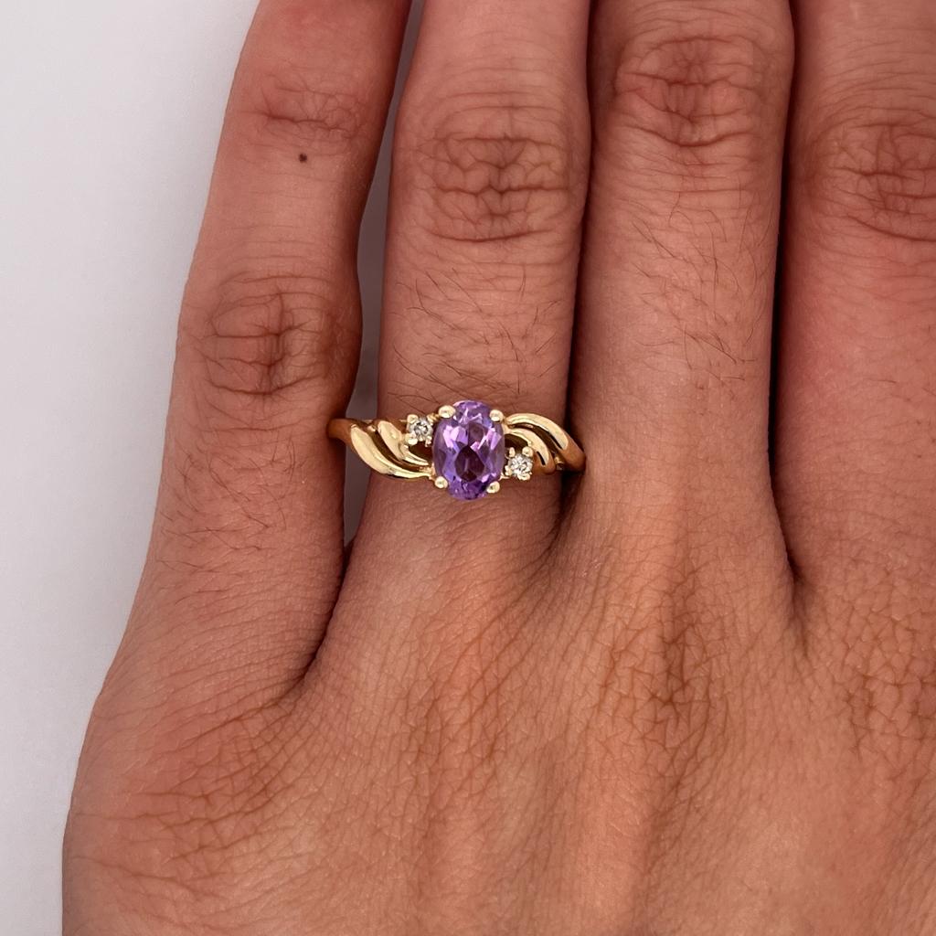 Celebrate a February loved one with this sweeping and swirling amethyst and diamond ring. This could make a perfect graduation gift or push present! The oval amethyst is the color of a silky purple flower with dew drops sparkling in the morning sun!