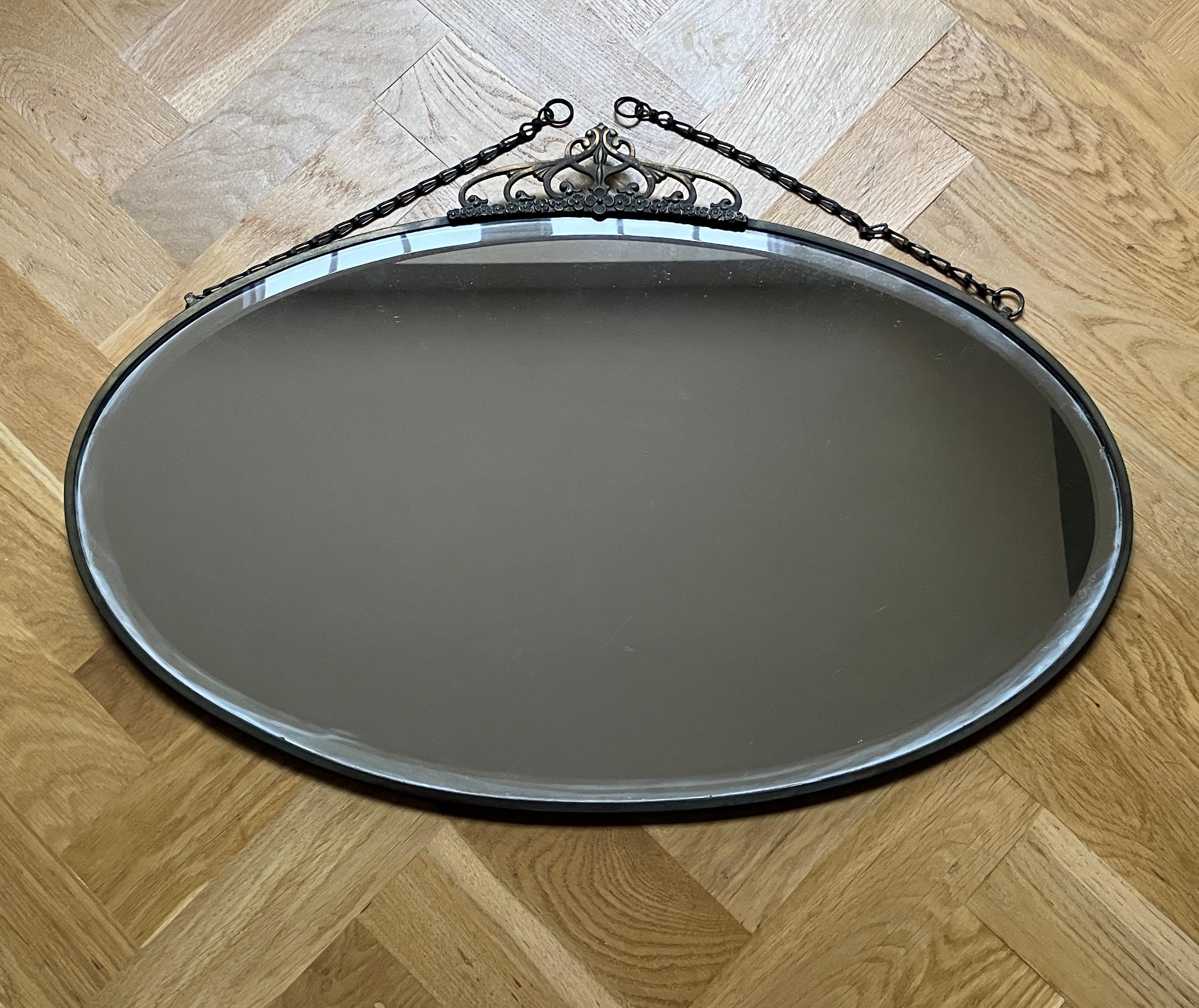 Brass Oval antique Art Nouveau mirror with a thin brass frame and crown  For Sale