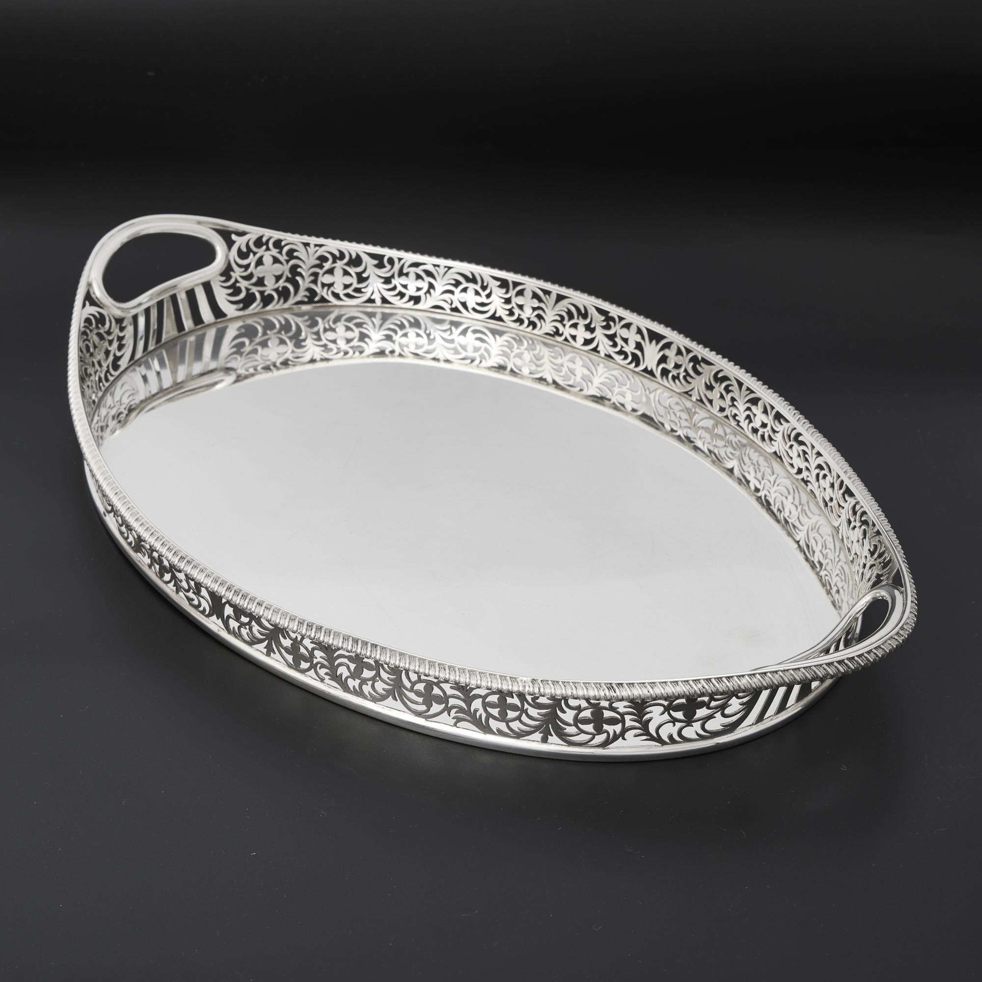 Ravissant plateau à galerie en argent ancien, avec une galerie en forme de bateau et percée à la main, décorée d'un feuillage et de fleurs stylisés et complexes. La bordure est ornée d'un joli godron français appliqué.

Poids : 1496 g (48.1 troy ozs)