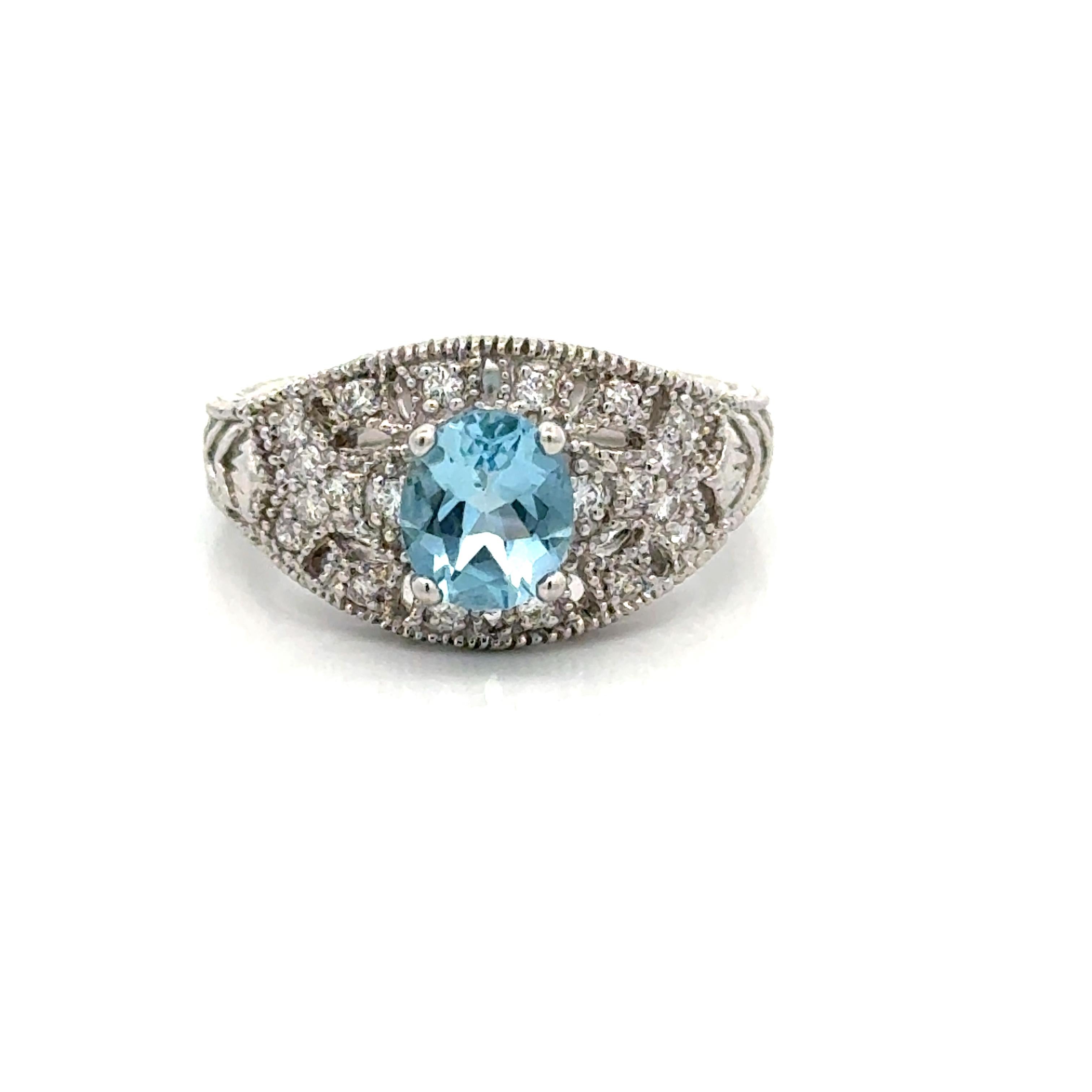 Dieser Ring aus 14-karätigem Weißgold zeichnet sich durch einen atemberaubenden ovalen Aquamarin in der Mitte aus, der durch komplizierte Details und eine Maserung hervorgehoben wird. Das klassische Design bietet einen Hauch von Vintage-Eleganz.