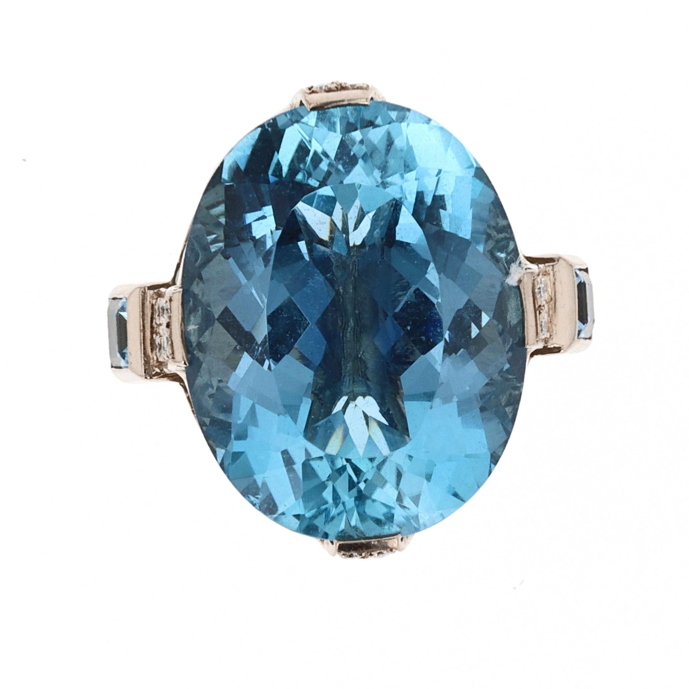 This 18k white gold cocktail ring is centered around a blue oval brilliant aquamarine of approximately 20cts.  
The sides of the ring are embellished with 42 round brilliant diamonds totaling approximately 0.45cts, 68 round brilliant aquamarines