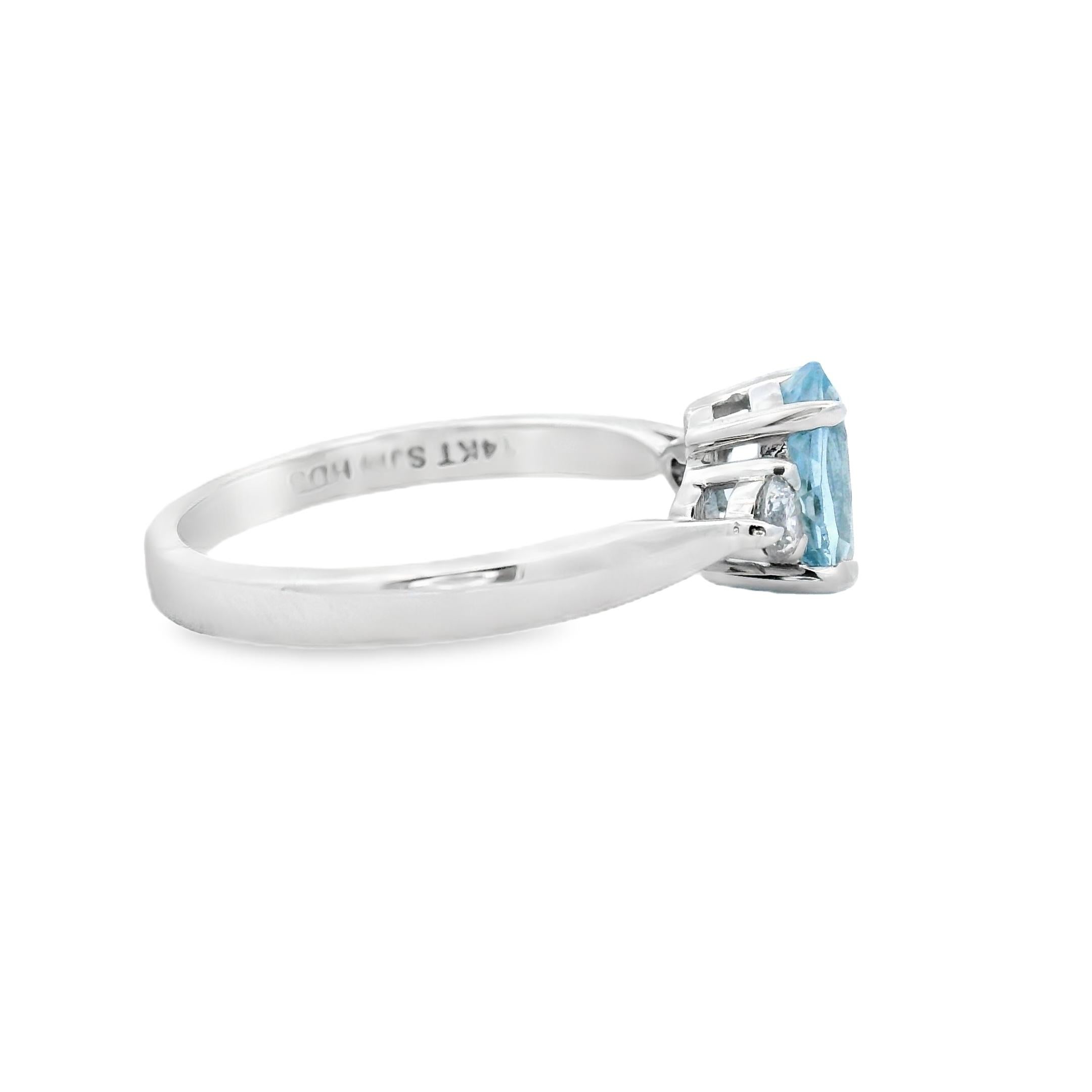 Délicate dans son profil mais riche en détails, cette élégante bague en aigue-marine et diamants est réalisée en or blanc 14K lumineux. Au centre se trouve une aigue-marine ovale de 1,05 carat mesurant 8 x 6 mm, prisée pour sa clarté cristalline et