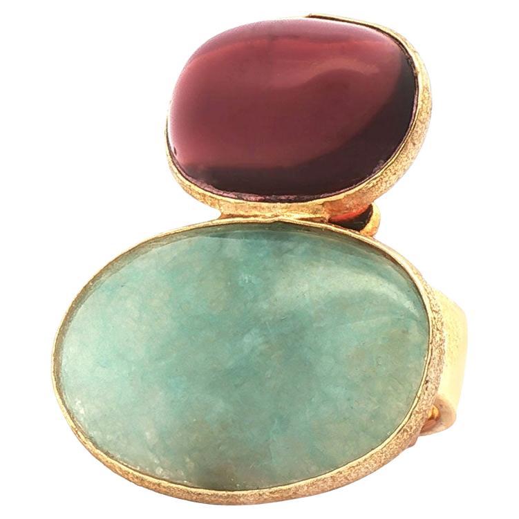 Audace, bello e assolutamente unico: questo accattivante anello da cocktail è una vera e propria dichiarazione di stile. L'anello presenta una coppia di gemme di grande effetto: un'acquamarina ovale dai toni tenui e un quarzo ovale dai toni prugna,