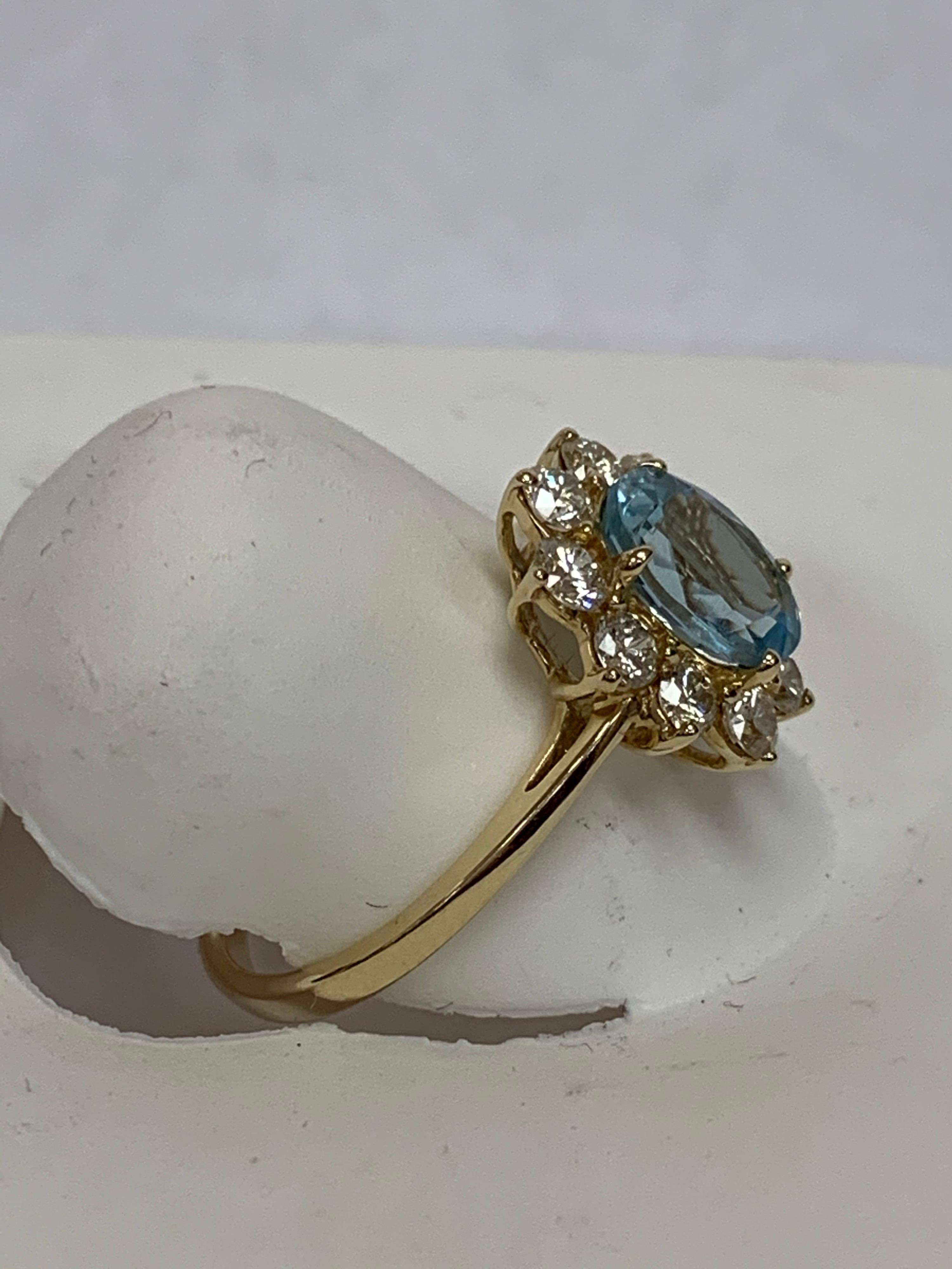 Artisan Oval Aquamarine and White Round Diamond Ring Set in 14 Karat Yellow Gold