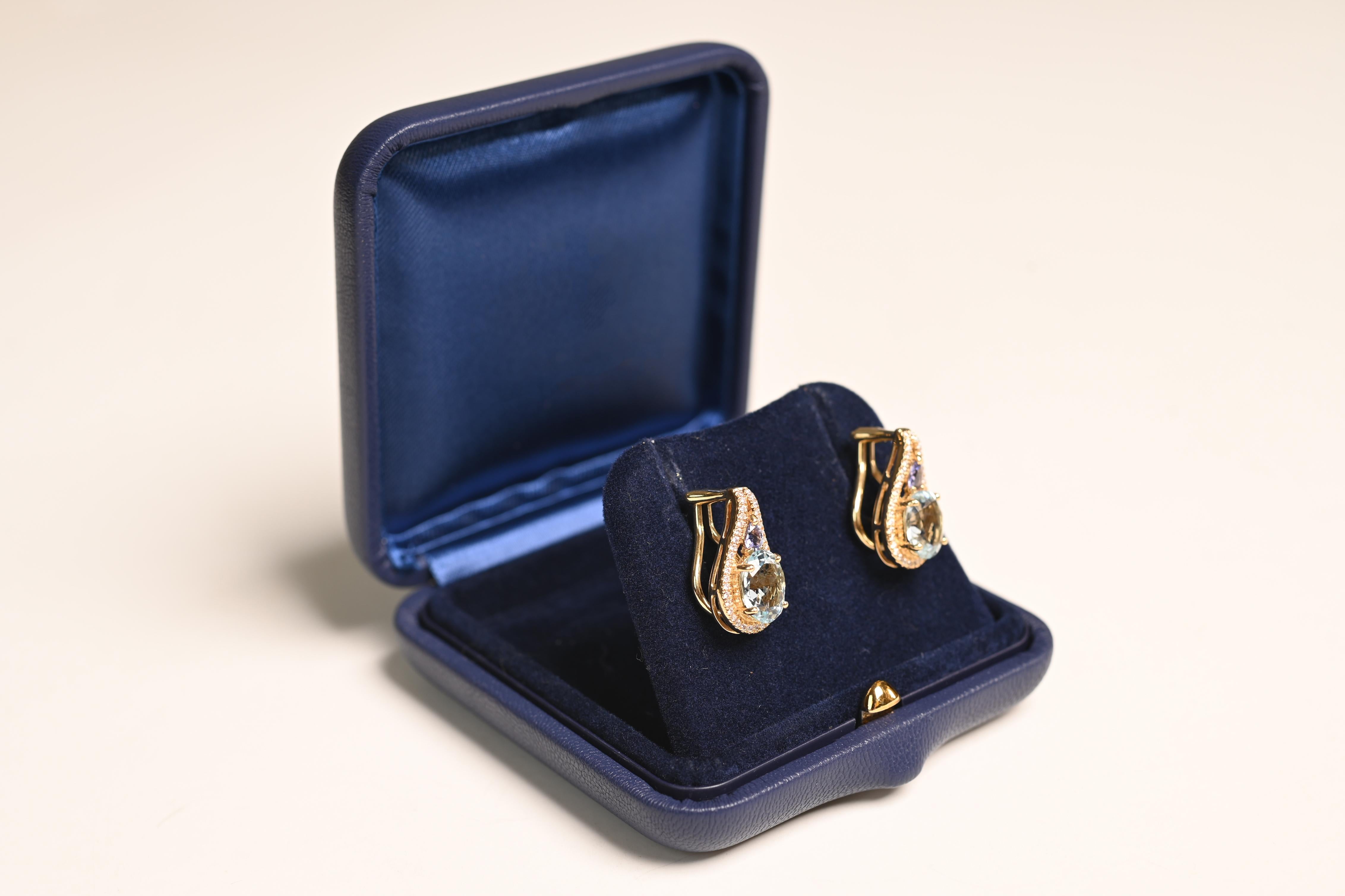 Questo squisito paio di orecchini con acquamarina e tanzanite è una vera e propria testimonianza di eleganza e maestria. Ogni orecchino sfoggia un'ipnotica acquamarina dal taglio ovale, con un peso complessivo di circa 3,69 carati. Le acquemarine