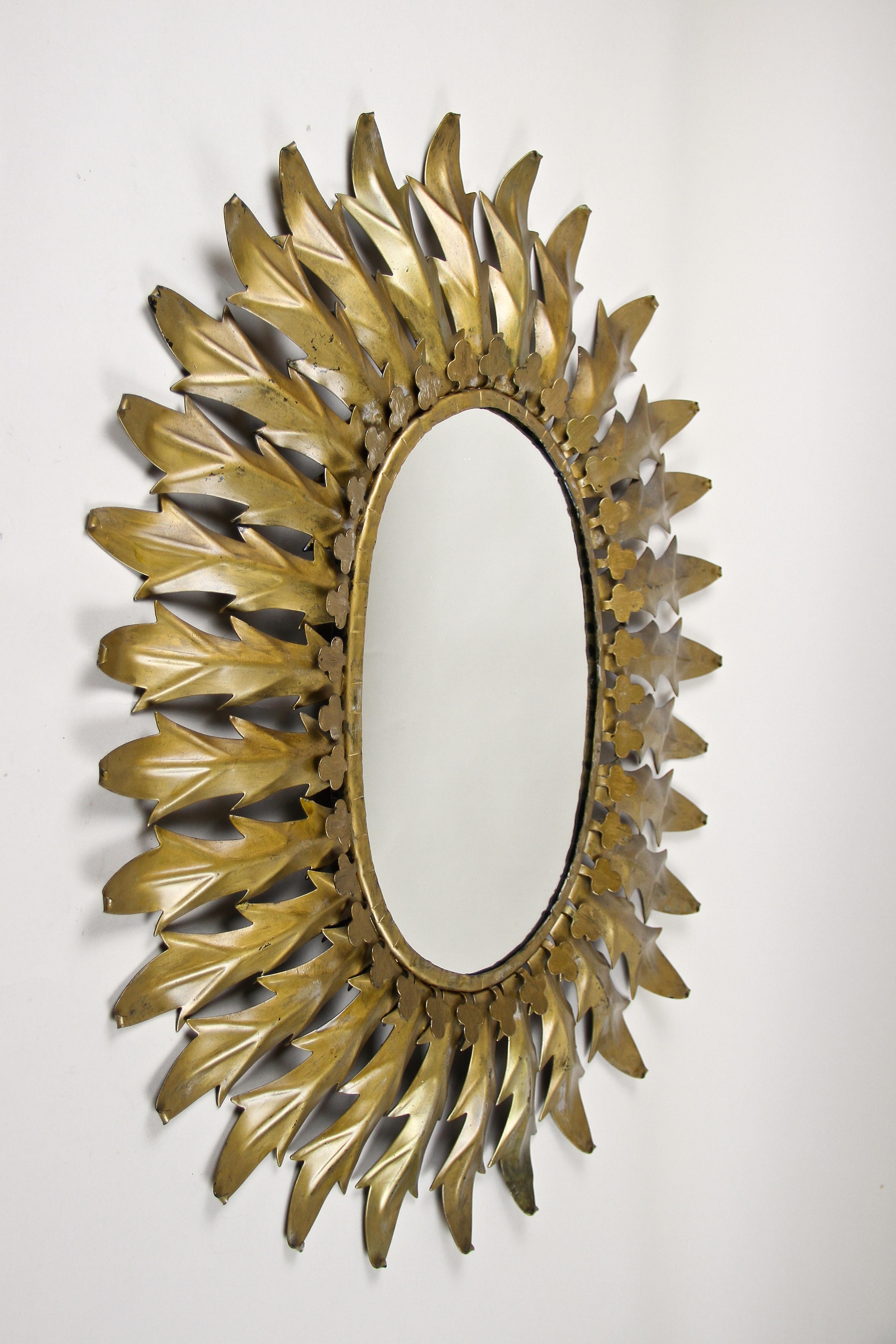 Außergewöhnlicher französischer Sunburst-Wandspiegel aus der Zeit des Art déco um 1920. Der Anfang des 20. Jahrhunderts in Frankreich handgefertigte ovale Spiegel besticht durch sein kunstvolles Design mit schön geformten großen Blättern aus