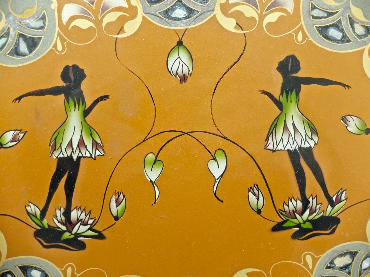 Sehr schönes Tablett mit Hinterglasmalerei und Perlmutt-Intarsien.
2 anmutige Tänzerinnen auf Seerosen, umrahmt von floralen Motiven. Einfassung mit Flechtwerk und 2 Griffen.