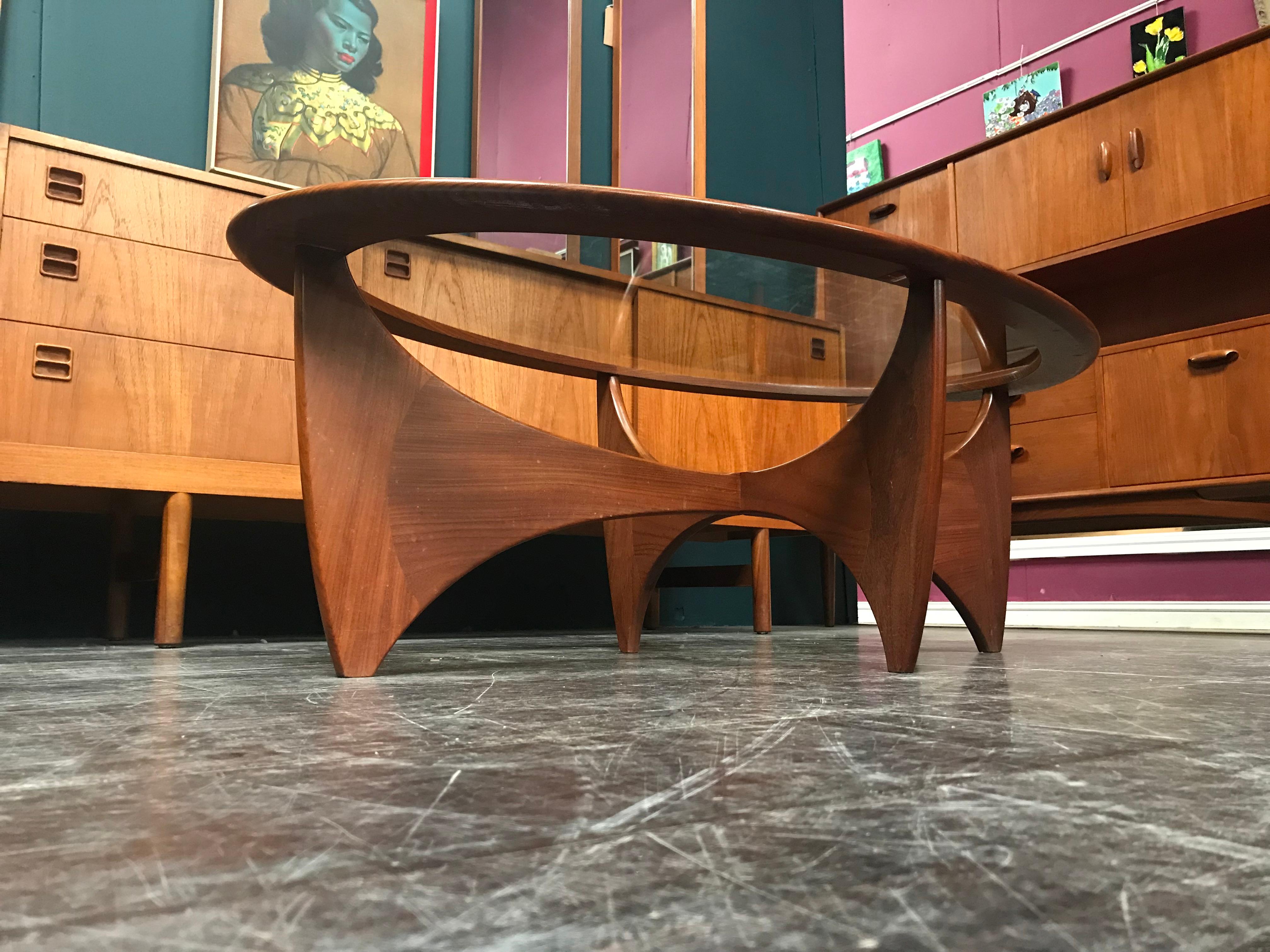 This Astro oval stained teak and glass coffee table was designed by Victor Wilkins for G-Plan, and was produced in England around the 1960s. British furniture designer Victor Bramwell (V.B.) Wilkins is best known for his Fresco range for