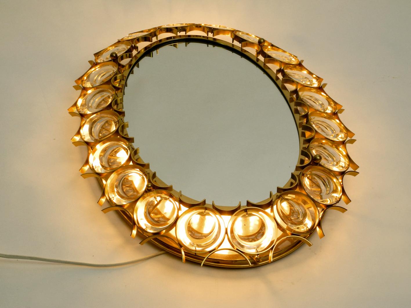 Beautiful very luxurious 1960s large oval Palwa wall mirror with heavy brass frame and 20 large crystal stones. Manufacturer Palme & Walter in the 1960s. Shiny brass without damages. The crystal stones are without damages and all complete. No