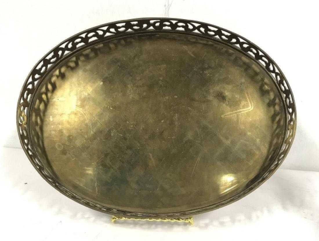 Oval brass serving tray with gallery. Intricate cut outs along border. Measures 10 inches wide by 13.5 inches long. Decorative table top accessory. A handsome tray with intricate, yet modern influences to work with any decor. Perfect for the bar or