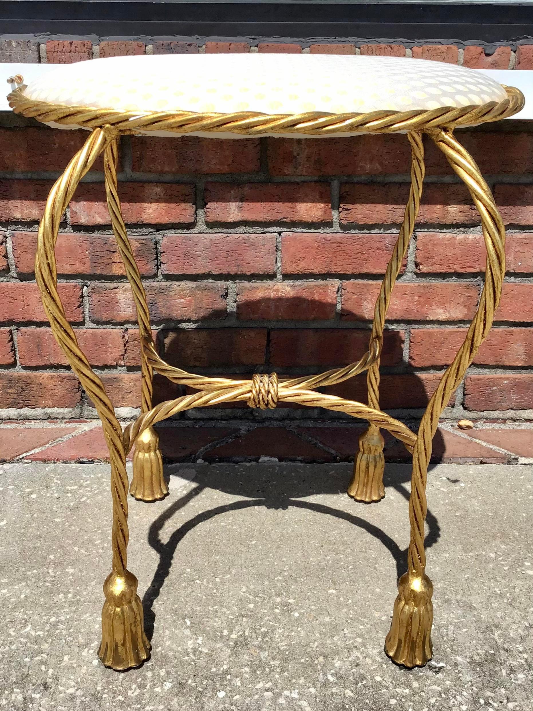 Nice oval bench with base made with metal tassel motifs in gold and a top with fabric.