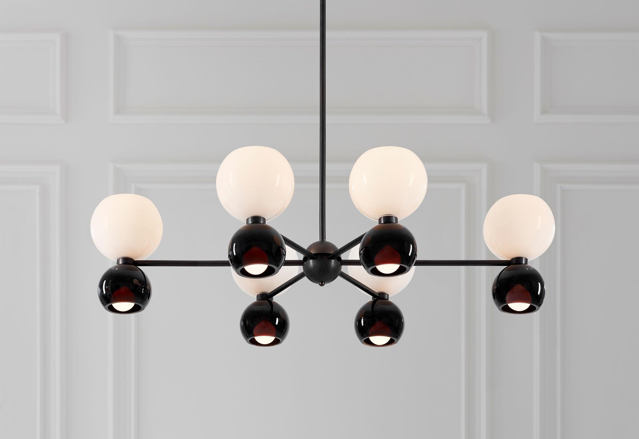 Going formal in black and white, the Betty Oval Chandelier showcases luminous hand blown glass. Classic Midcentury forms are homage to the era of Italian designed chandeliers.

The Betty oval chandelier is complimentary to the Betty Sconce.