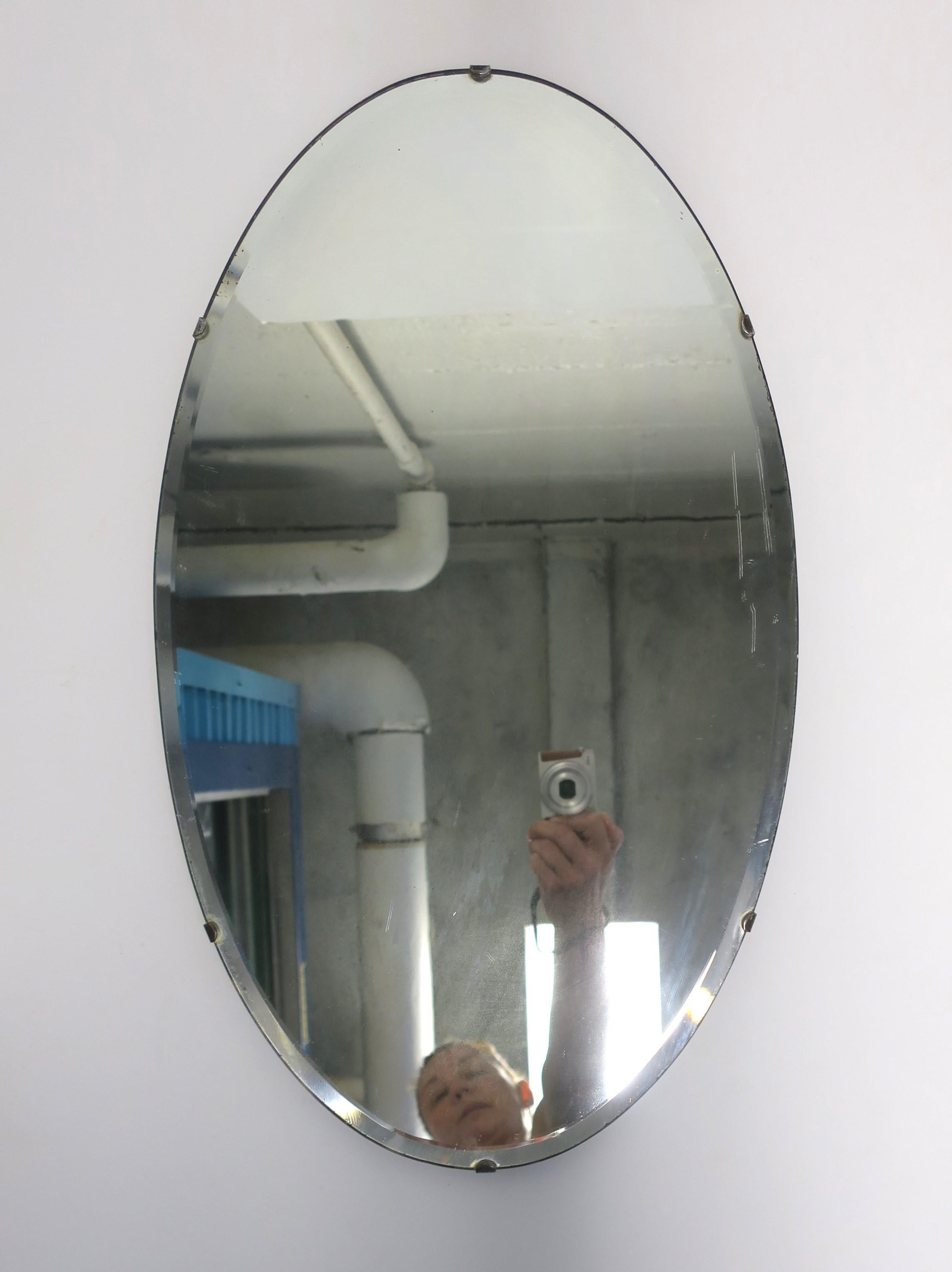 Miroir mural ovale biseauté, vers le début du 20e siècle, États-Unis. Miroir ovale à bord biseauté et préparé pour être accroché au dos, comme illustré. Un miroir mural idéal pour tout type de mur, y compris un meuble-lavabo, un placard, une salle