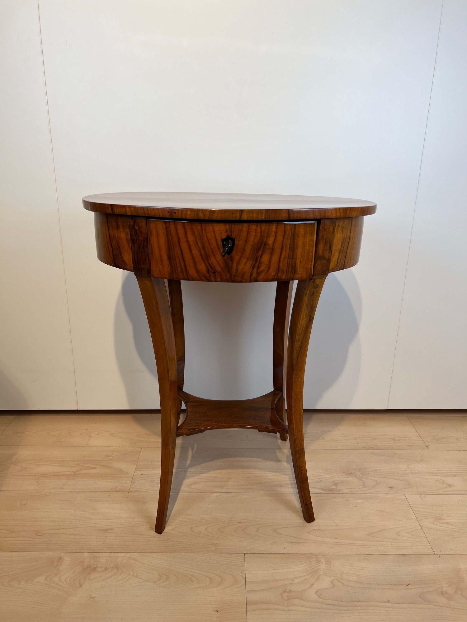 Oval Biedermeier side table or Sewing table with drawer, walnut veneer, South Germany circa 1820
 
Walnut veneered on the top and apron and solid on the four legs.
Front centre with lockable drawers. Restored and hand polished with shellac 
