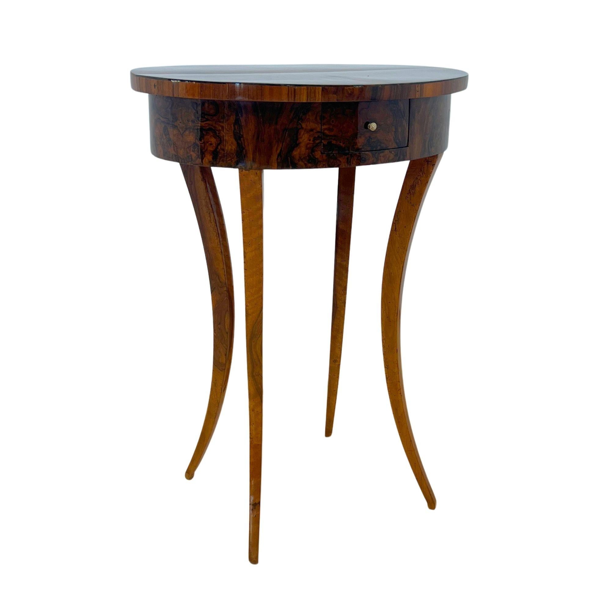 Elegante table d'appoint ovale Biedermeier d'Allemagne du Sud vers 1820.
Placage de noyer sur bois tendre. Placage en forme de livre et d'étoile sur le plateau et placage en ronce de noyer sur le cadre. Quatre pieds carrés incurvés en noyer