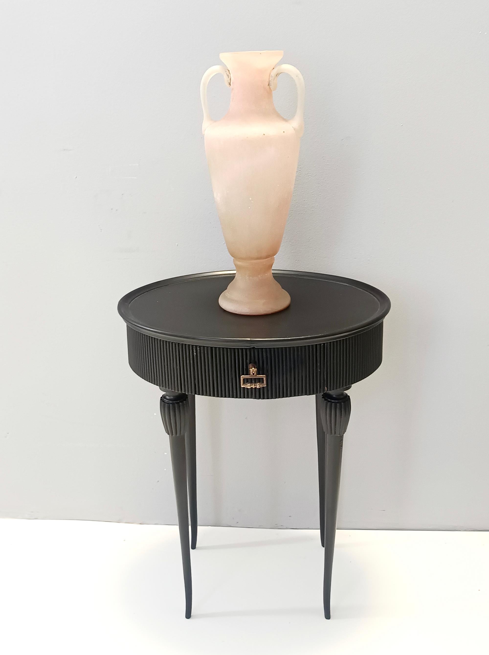 Made in Italy, 1950s. 
It features an ebonized beech frame with a brass handle. 
The edge is ribbed and its legs are in turned wood and slightly curved in the end. 
It can also be used as a single nightstand.
It is a vintage piece, therefore it
