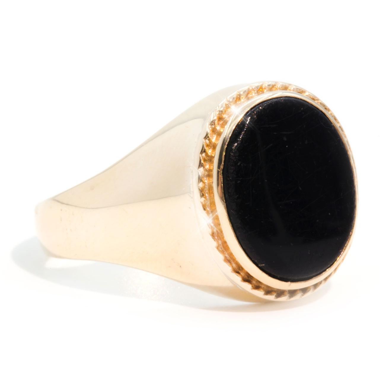 Crafted in 9 carat yellow gold is this handsome men's or women's vintage signet ring featuring a flat oval black onyx set inside a detailed rope patterned domed top. We have named this understated piece The Remington Ring. The Remington Ring has a