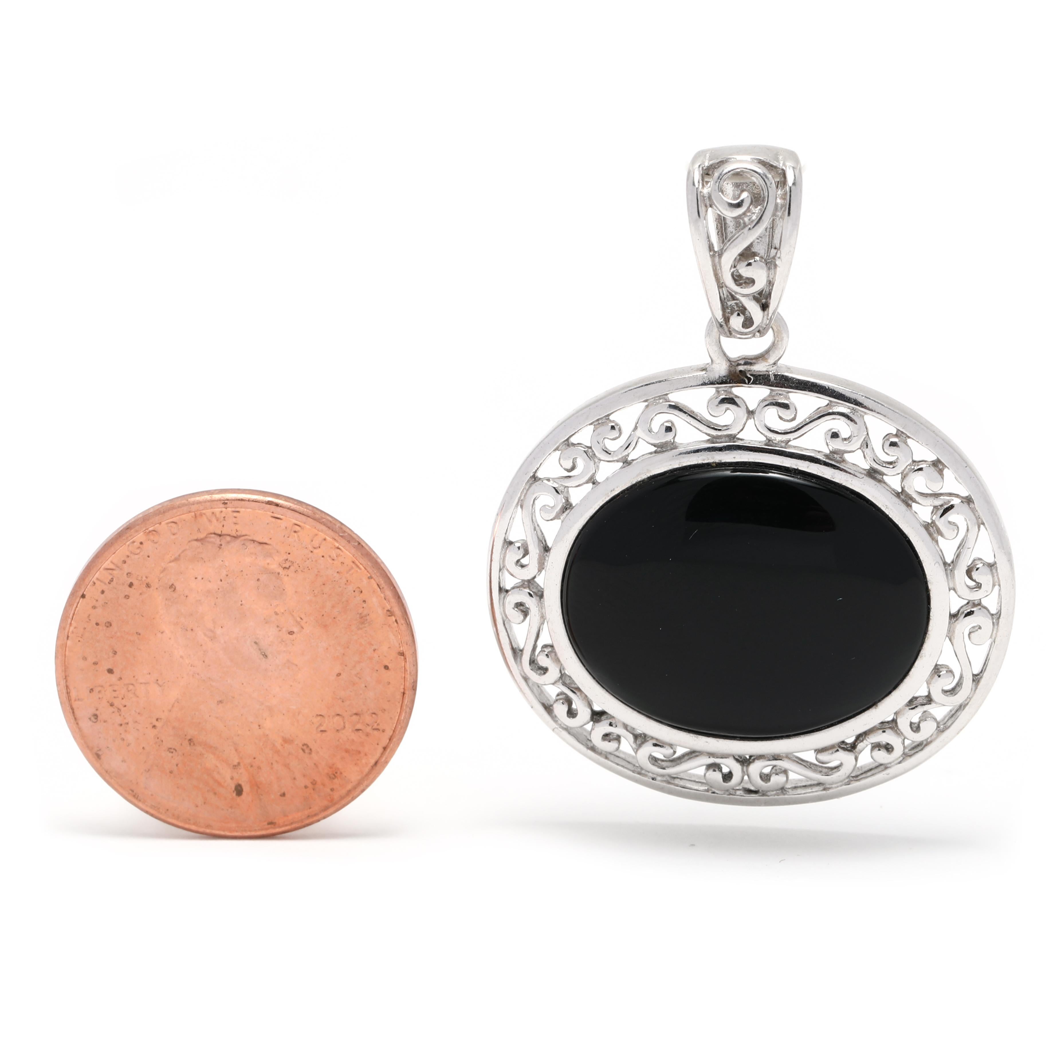 This stunning vintage black onyx filigree pendant is crafted from sterling silver and features an oval black onyx stone. The intricate filigree design is sure to make a statement. The pendant measures 1 3/8 inches in length and is a perfect addition