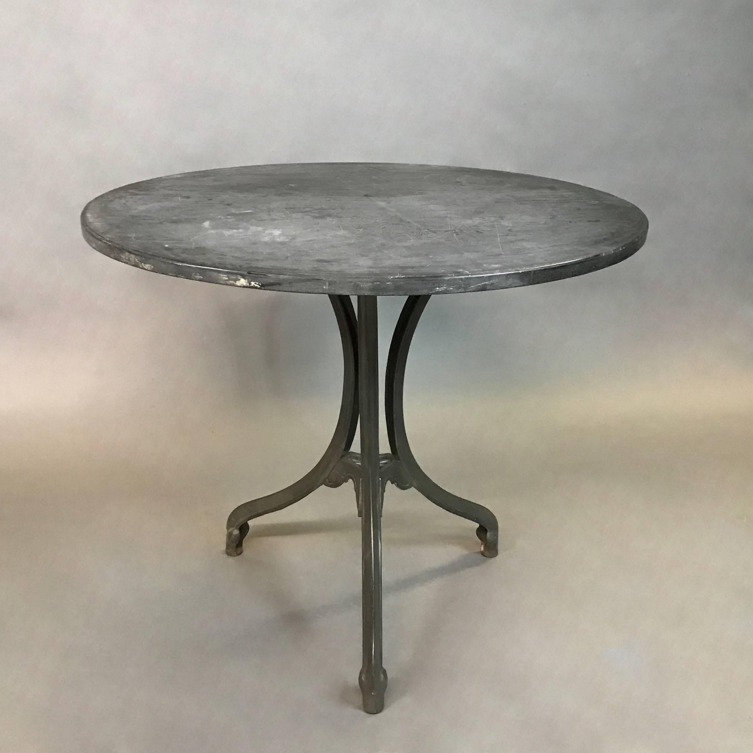 Art Deco, café, bistro, dining table features an oval shape, black slate top with an elegant, three prong, cast iron, pedestal base.