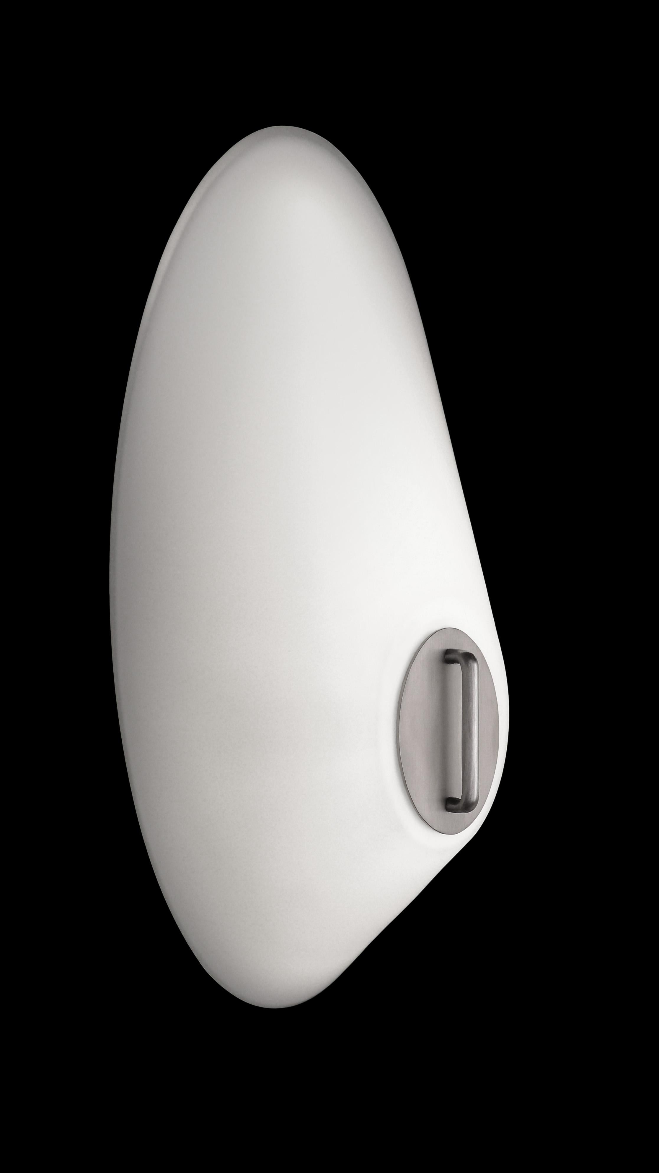 Oval shaped glass sconce. In the manner of Streamline Moderne. Brushed aluminum oval detail at center. LED Lamped, 3000k standard color temperature. Great for use in pairs.

Architect, Sandy Littman of Duesenberg LTD. and the American Glass Light