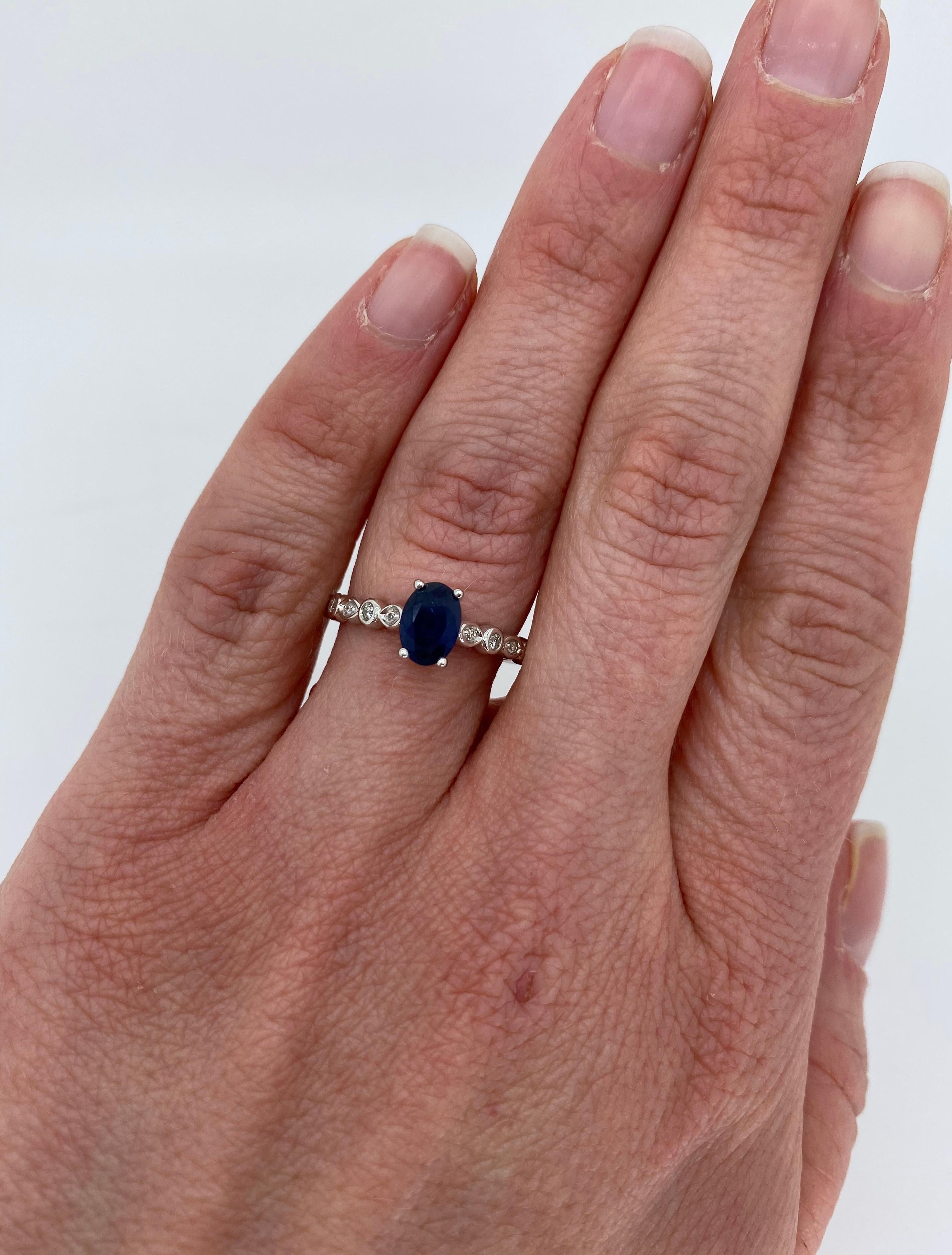 14k white gold sapphire ring with flanking diamond accents.

Gemstone: Sapphire & Diamonds
Gemstone Carat Weight:  Approximately 7.11 x 5.17mm
Diamond Carat Weight:  Approximately .10CTW
Diamond Cut: Round Brilliant Cut
Color: Average G-J
Clarity: