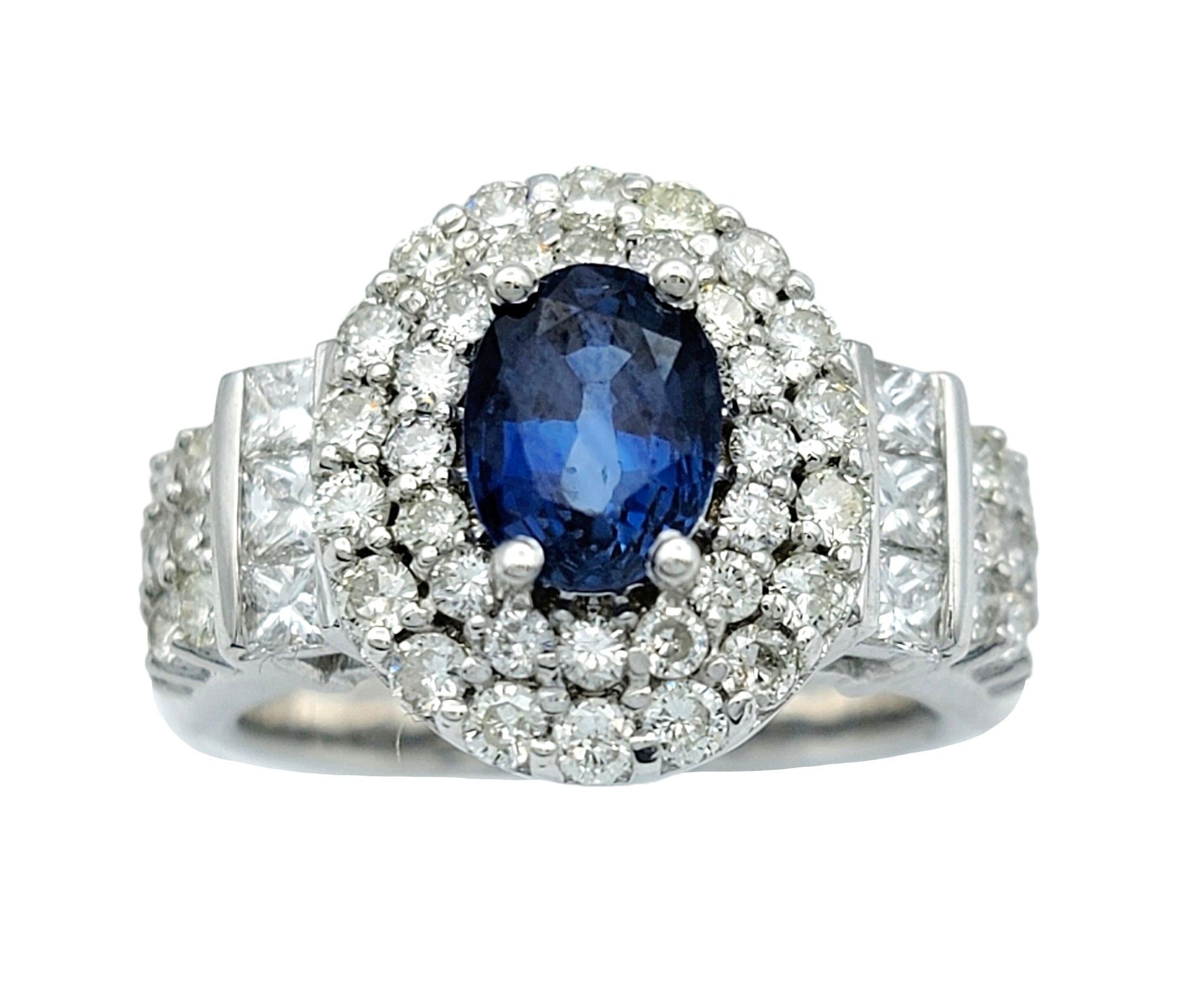 Ringgröße: 6

Dieser wunderschöne ovale Cocktailring mit blauem Saphir und doppeltem Diamantbesatz in strahlendem 14-karätigem Weißgold ist ein schillerndes Beispiel für Eleganz und Raffinesse. In seinem Zentrum zieht ein ovaler blauer Saphir mit