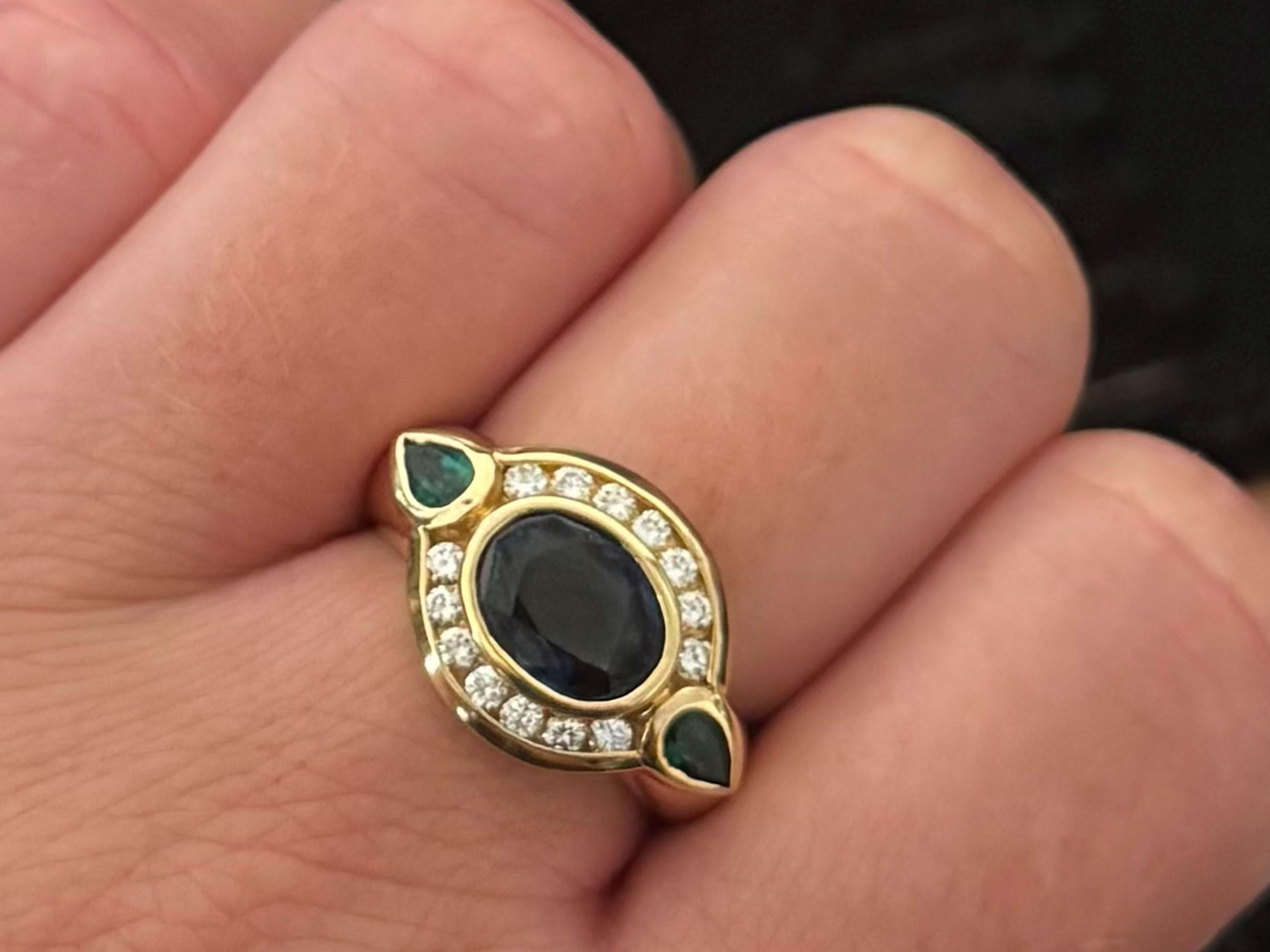 Oval Blue Sapphire Channel Set Diamond Halo Green Pear Shape Emeralds on the sides 14K Yellow Gold Ring
​
​Item Specifications:

Metal: 14K Yellow Gold

Ring Size: 7 (resizing available for a fee)

Ring Height: 13 mm tall

Total Weight: 6.5