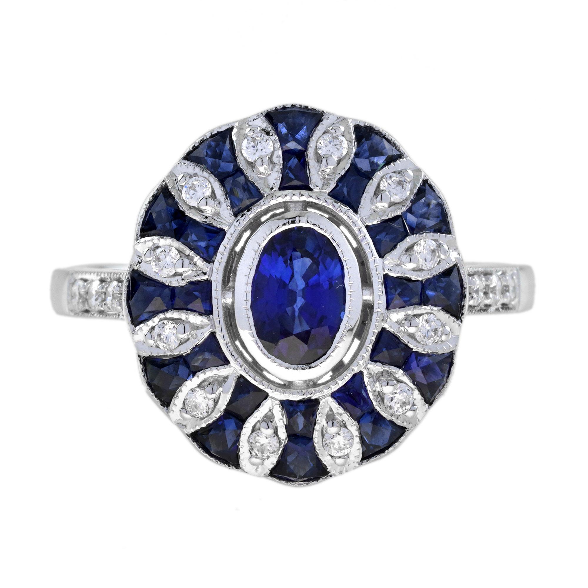 Este anillo de oro blanco es típico del periodo Art Déco. Es una mezcla de un diseño de objetivo y de racimo. En el centro hay un zafiro azul engastado en bisel, rodeado de zafiros azules y diamantes adicionales bien combinados. Hay pequeños