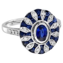 Anillo de oro blanco en mosaico con zafiro azul ovalado y diamantes estilo Art Déco engastado en halo