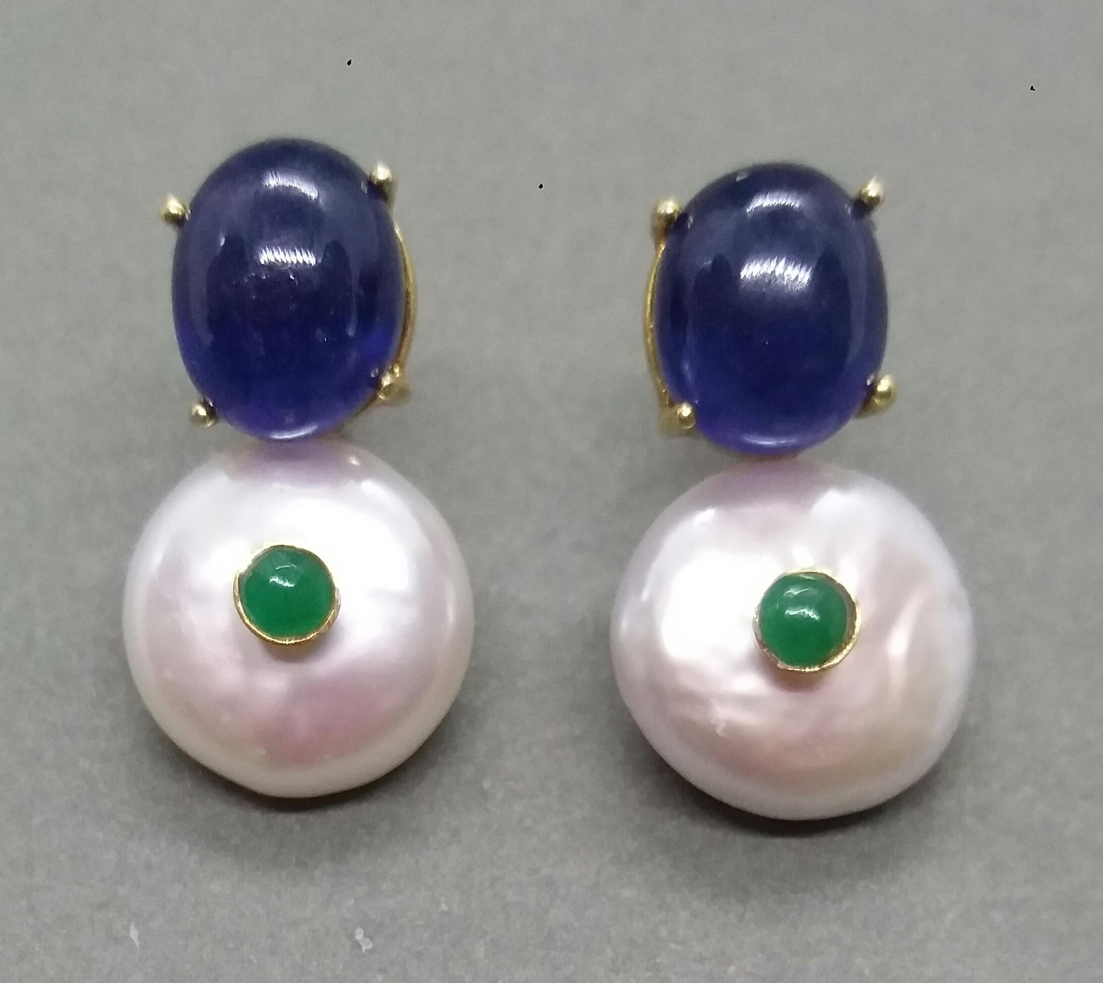 Simple chic stud earrings with a pair of Oval Blue Sapphire Cabs set in solid 14 Kt. yellow gold on the top and 2 Round Flat Fresh water pearls 15 mm in diameter with in the center a small round Emerald cabs also set in yellow gold 

In 1978 our