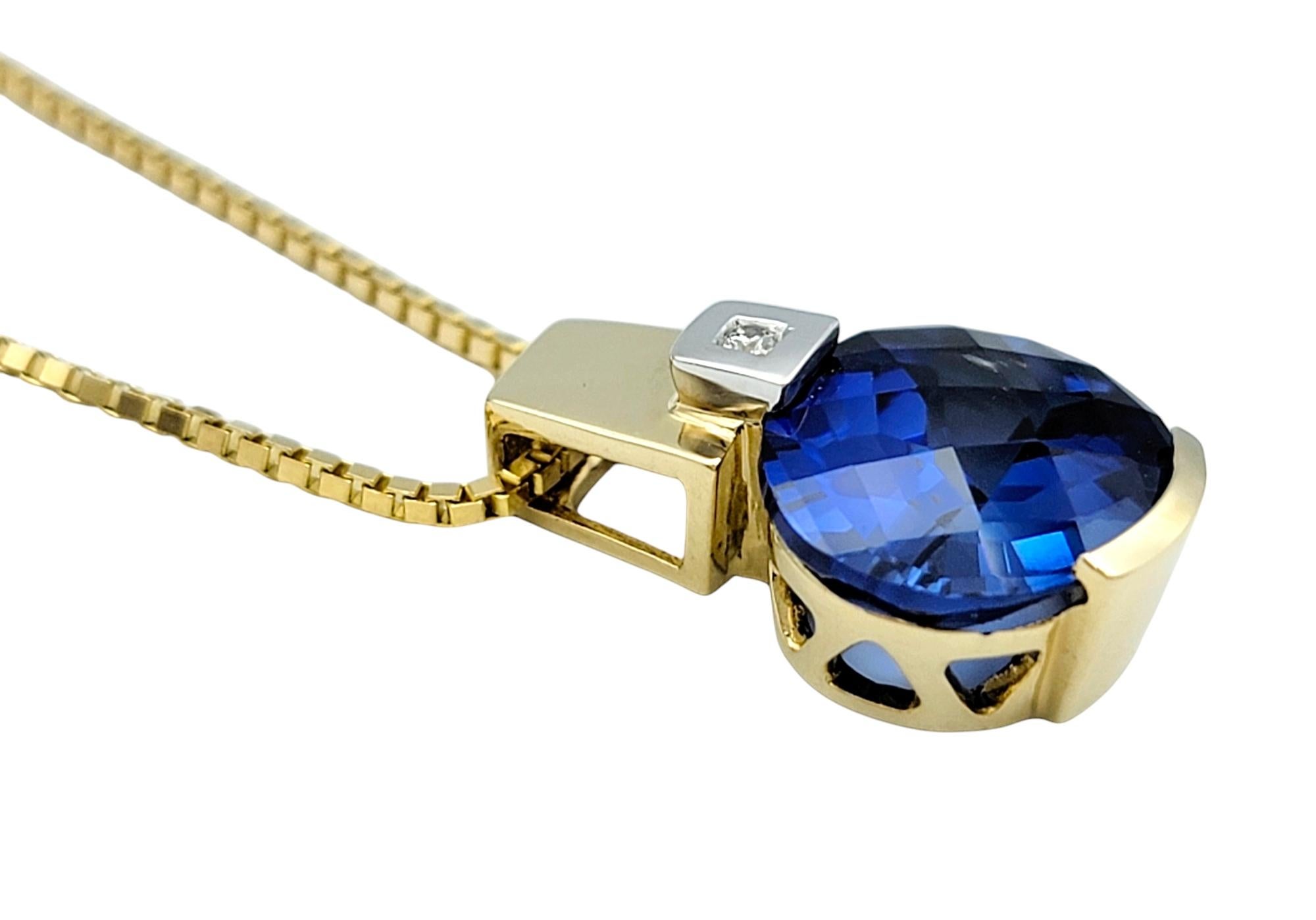 This stunning synthetic blue sapphire and natural diamond pendant is exquisitely set in 14 karat yellow and white gold. The pendant features a vibrant blue synthetic sapphire as the centerpiece, paired with a sparkling round diamond that adds