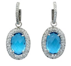 Oval Blue Topaz and Diamond Halo Huggie Dangle Earrings in 14 Karat White Gold
