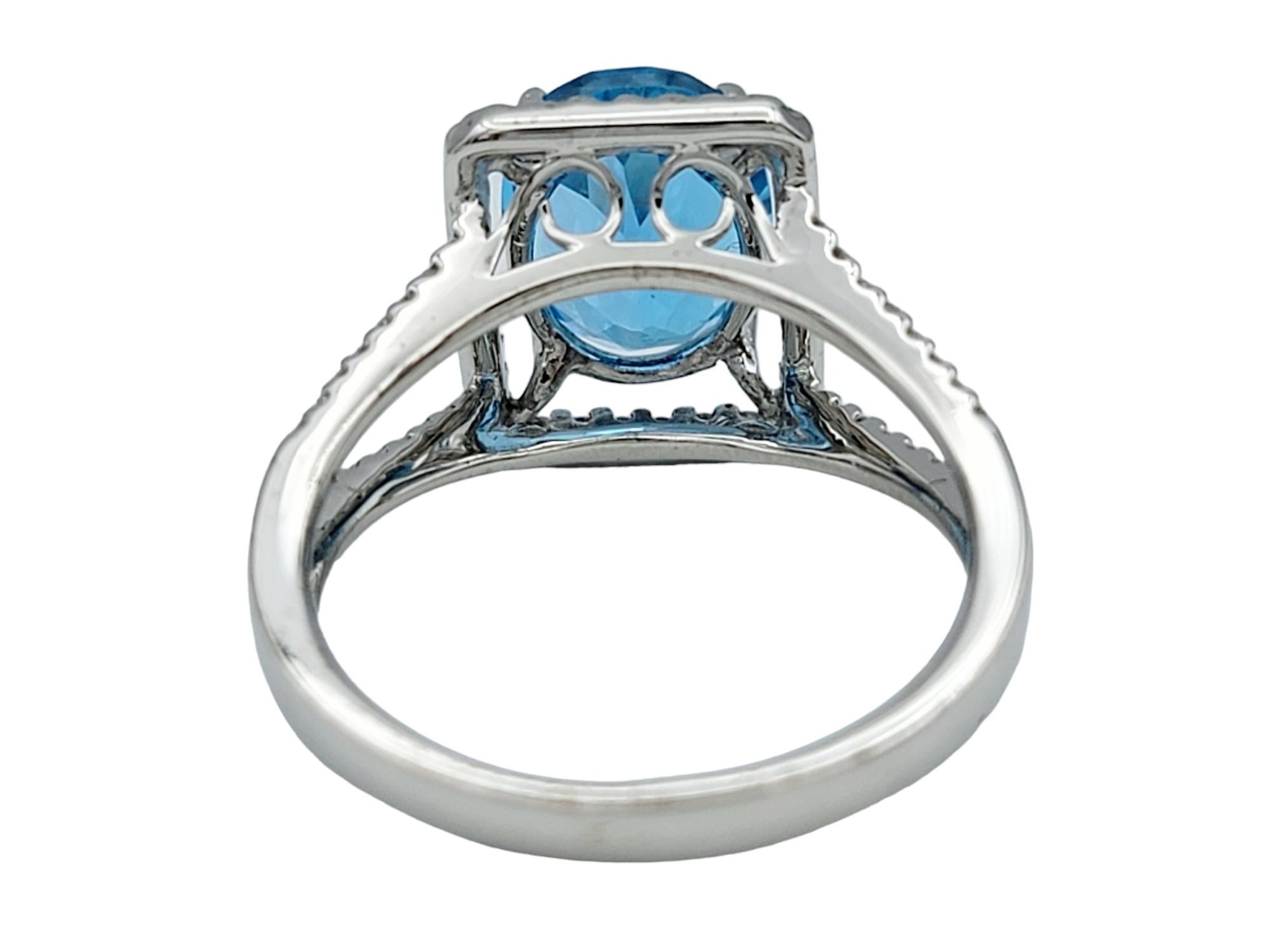 Bague à tige fendue en or blanc 18 carats, topaze bleue ovale et halo de diamants carrés en vente 1