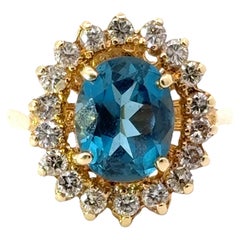 Ovaler blauer Topas, Diamant und Ring aus 14 Karat Gelbgold