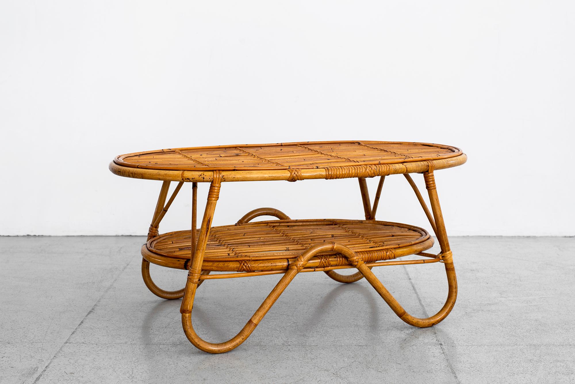 Italian rattan coffee table with curved legs and shelf.
 