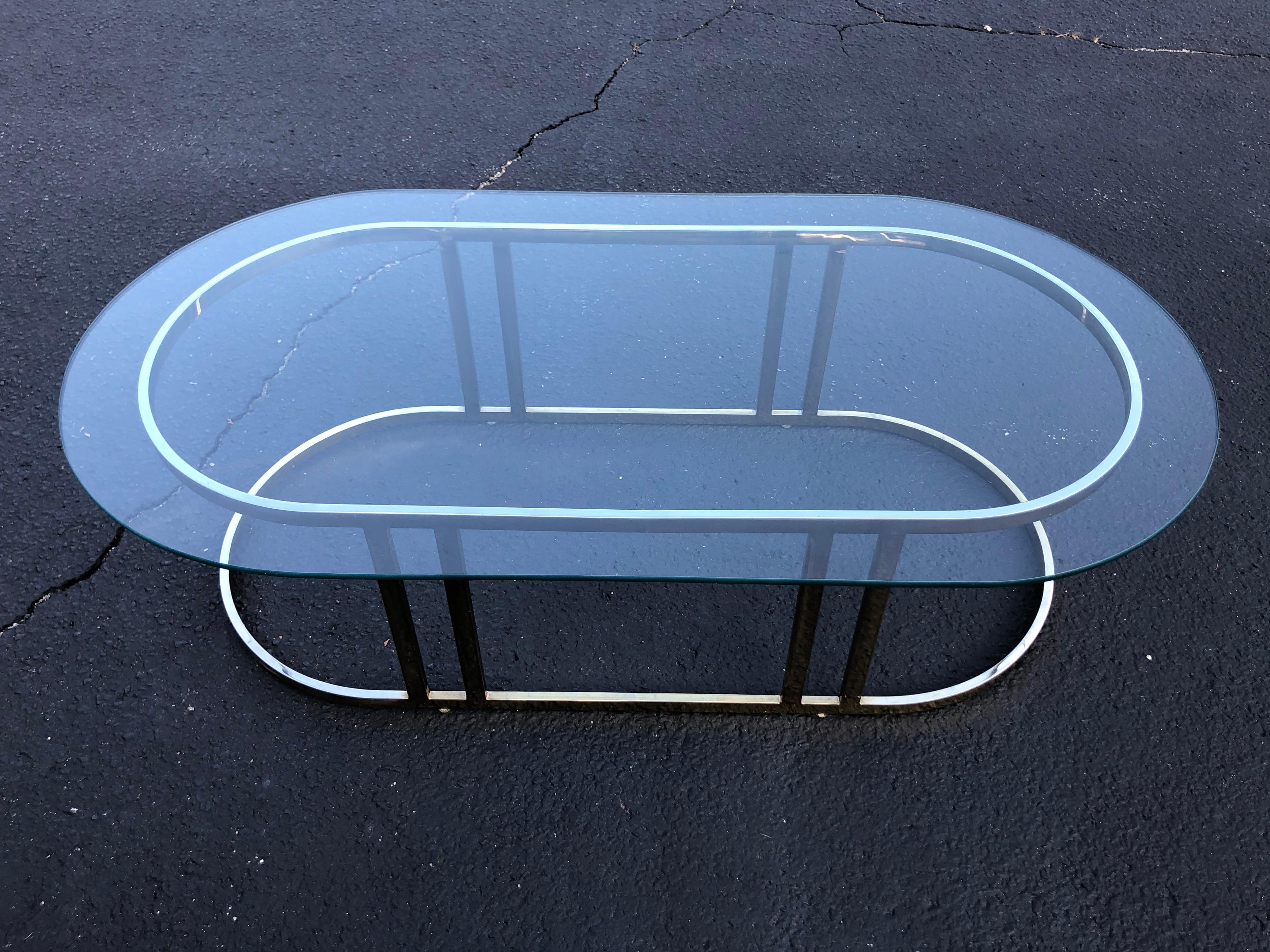 Oval brass and glass coffee table attributed to Milo Baughman. Minimalist racetrack design. Sleek and sexy.
 