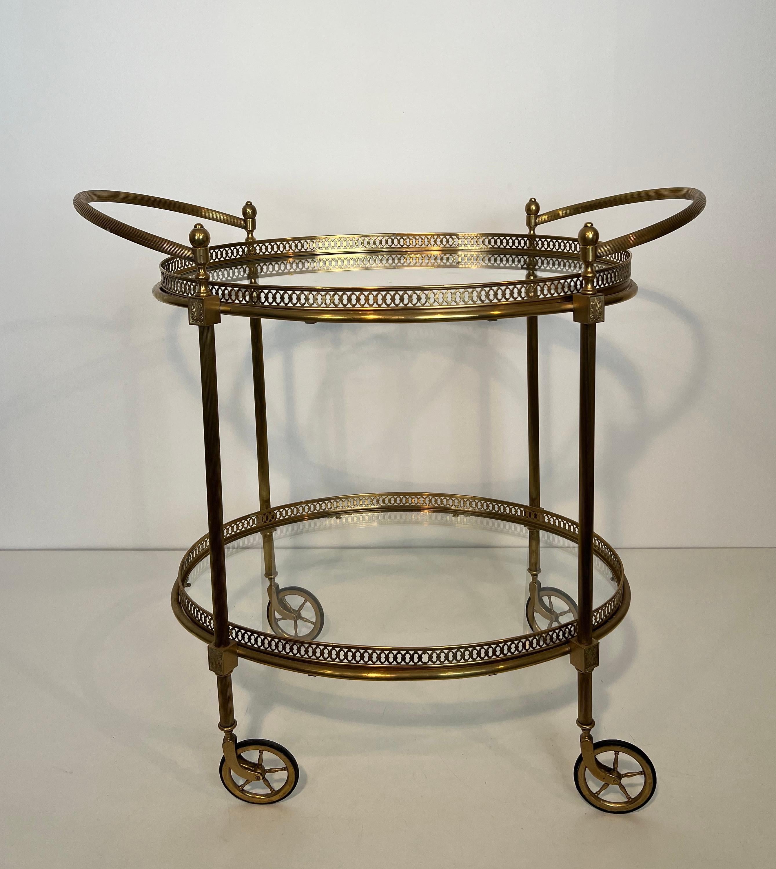 Ce très beau et élégant chariot de bar ovale de style néoclassique est en laiton avec des plateaux en verre. Il s'agit d'un ouvrage français de la Maison Jansen. Circa 1940