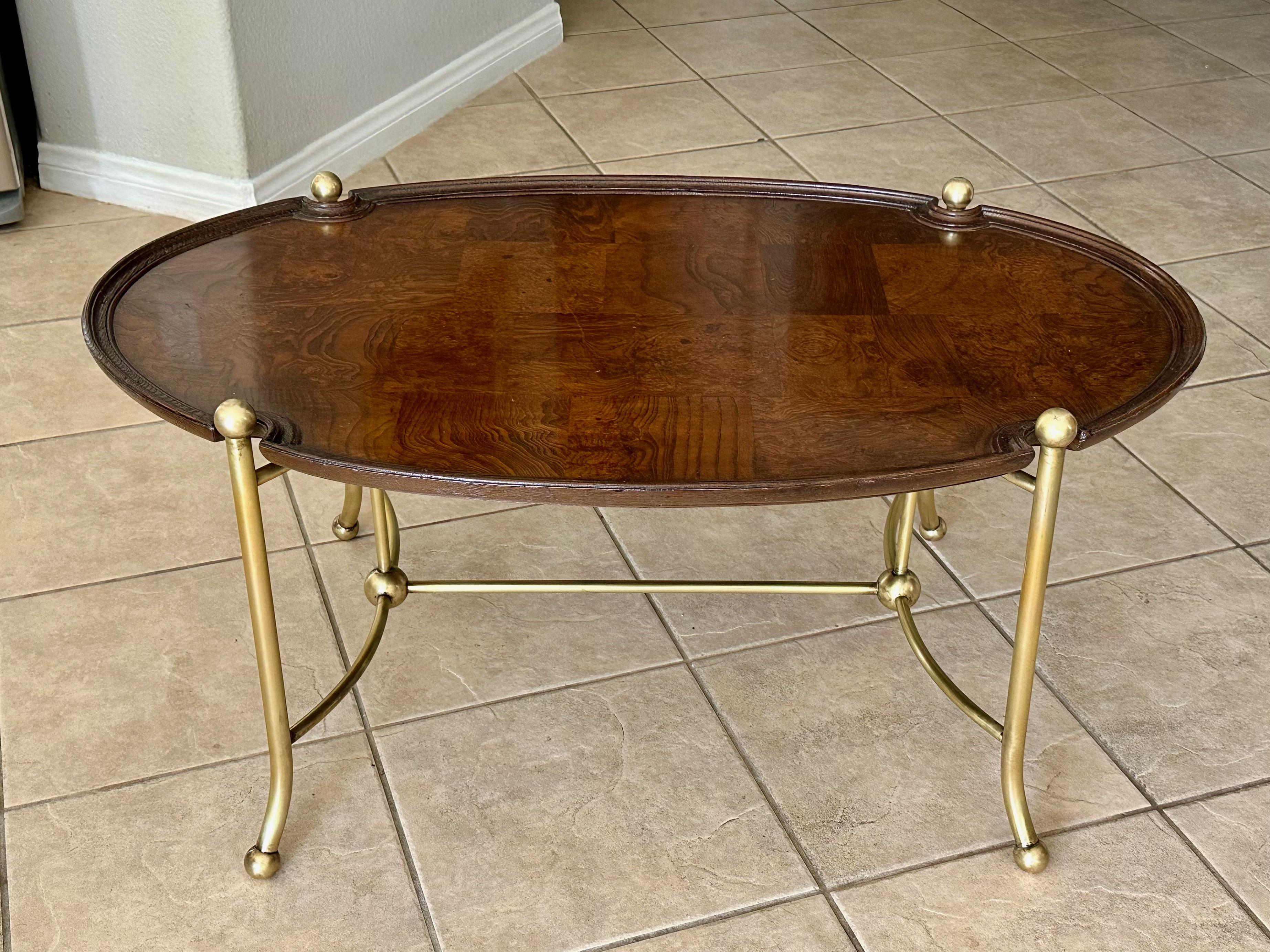 Mesa de centro o de cóctel ovalada con base de latón auténtico y tablero de madera burl de parche con bordes compuestos moldeados, fabricada por Hekman Furniture. 