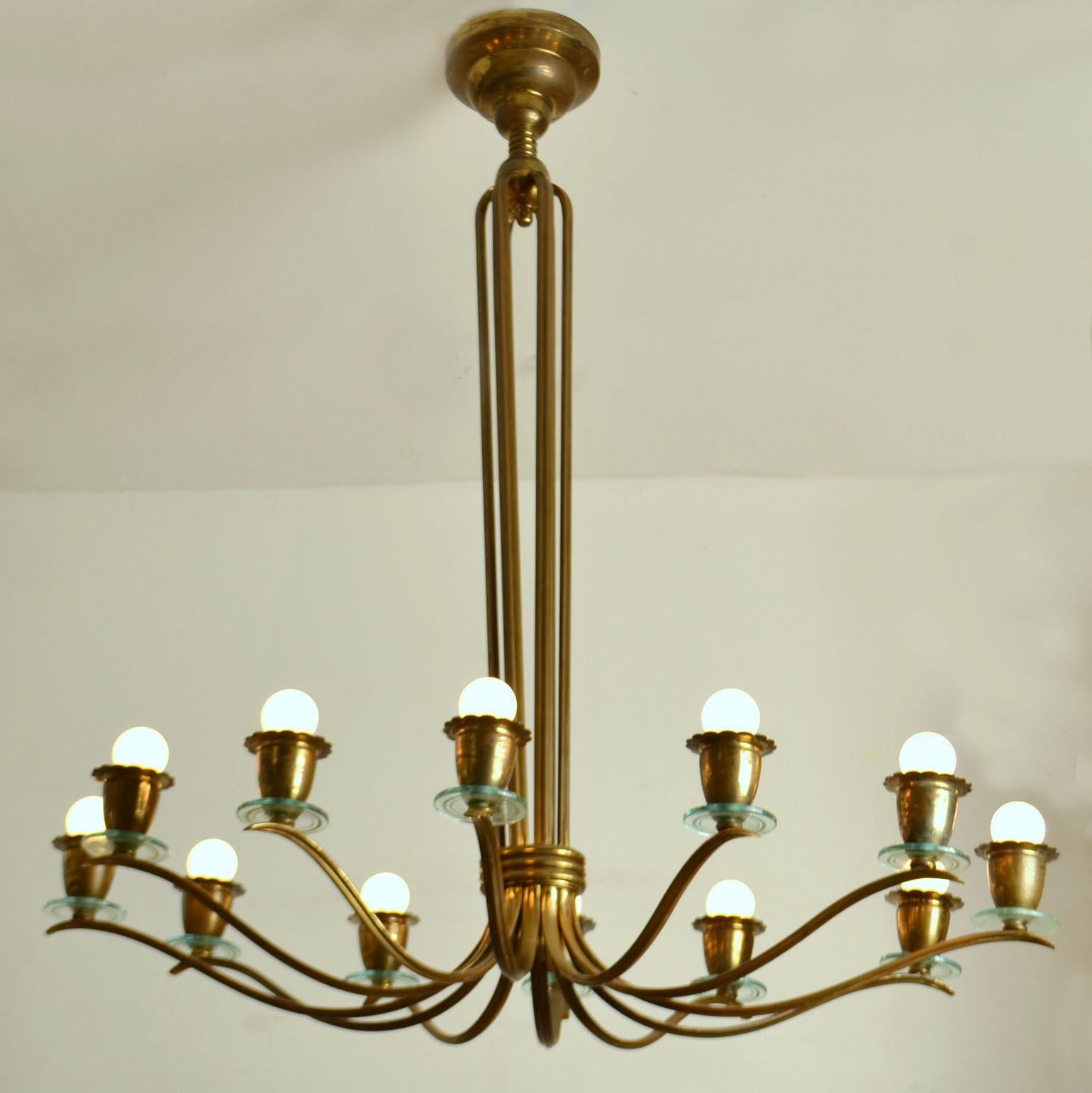 Oval brass chandelier designed in the style of Pietro Chiesa for the Italian manufacturer Fontana Arte in the 1940's is made in a brass structure with 12 arms and lights. At each end we find the bulb holder in the shape of a flower cup. The lights